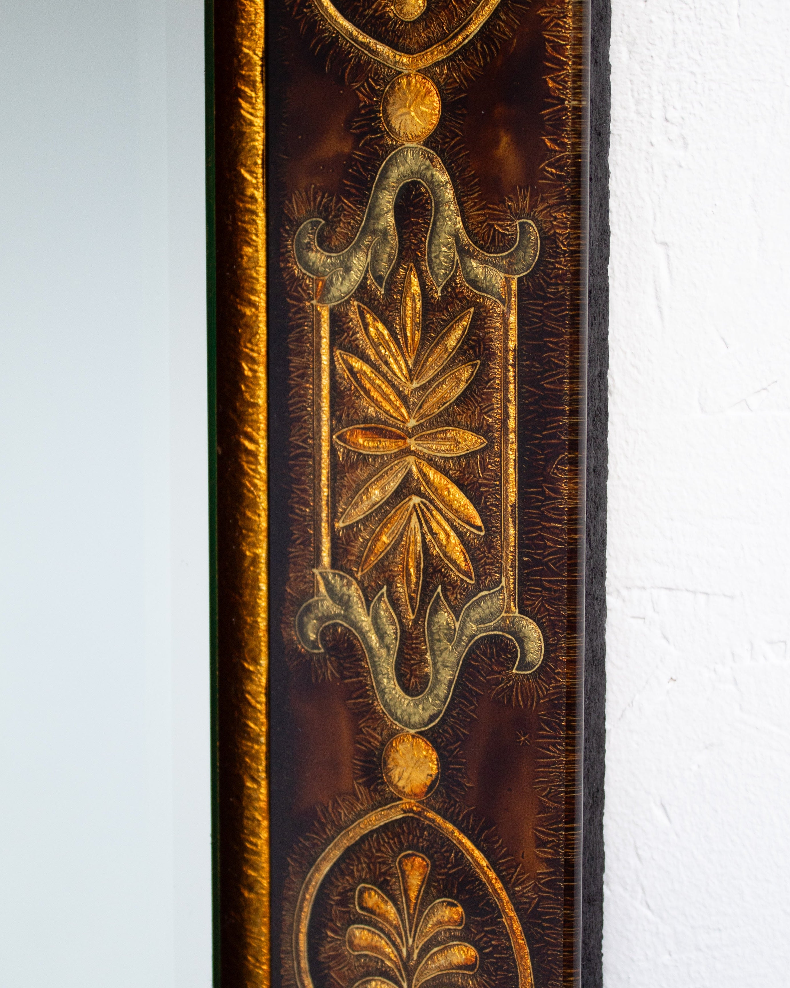 Ornate golden botanical detail of antique wall mirror frame