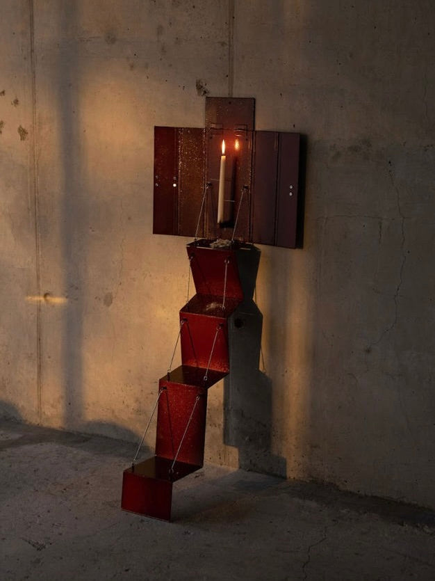 Wax Clock' Wall Candleholder — angled view with candle lit against concrete wall
