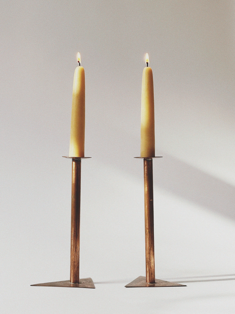 2 Copper Postmodern Candlesticks — close-up of candle flames and bases