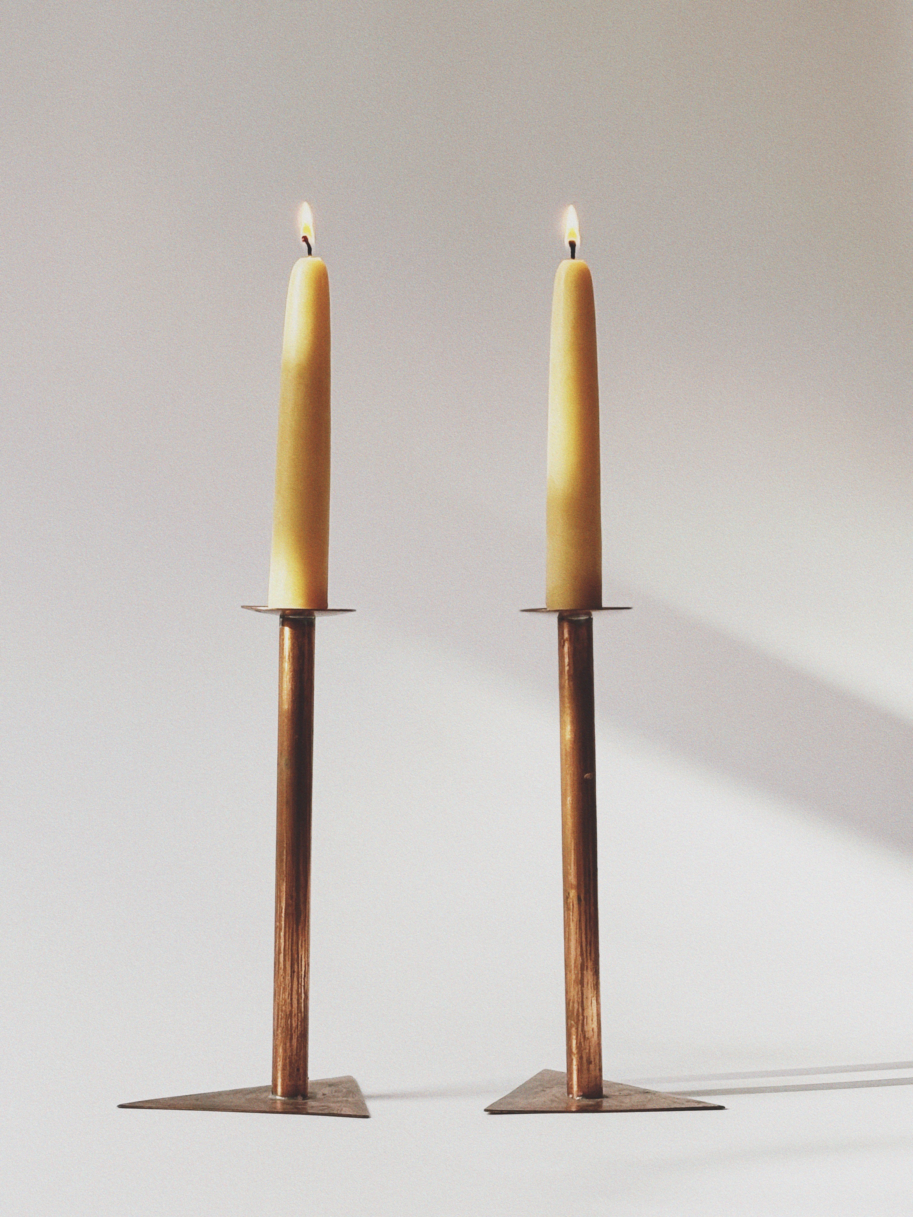 2 Copper Postmodern Candlesticks — close-up of candle flames and bases