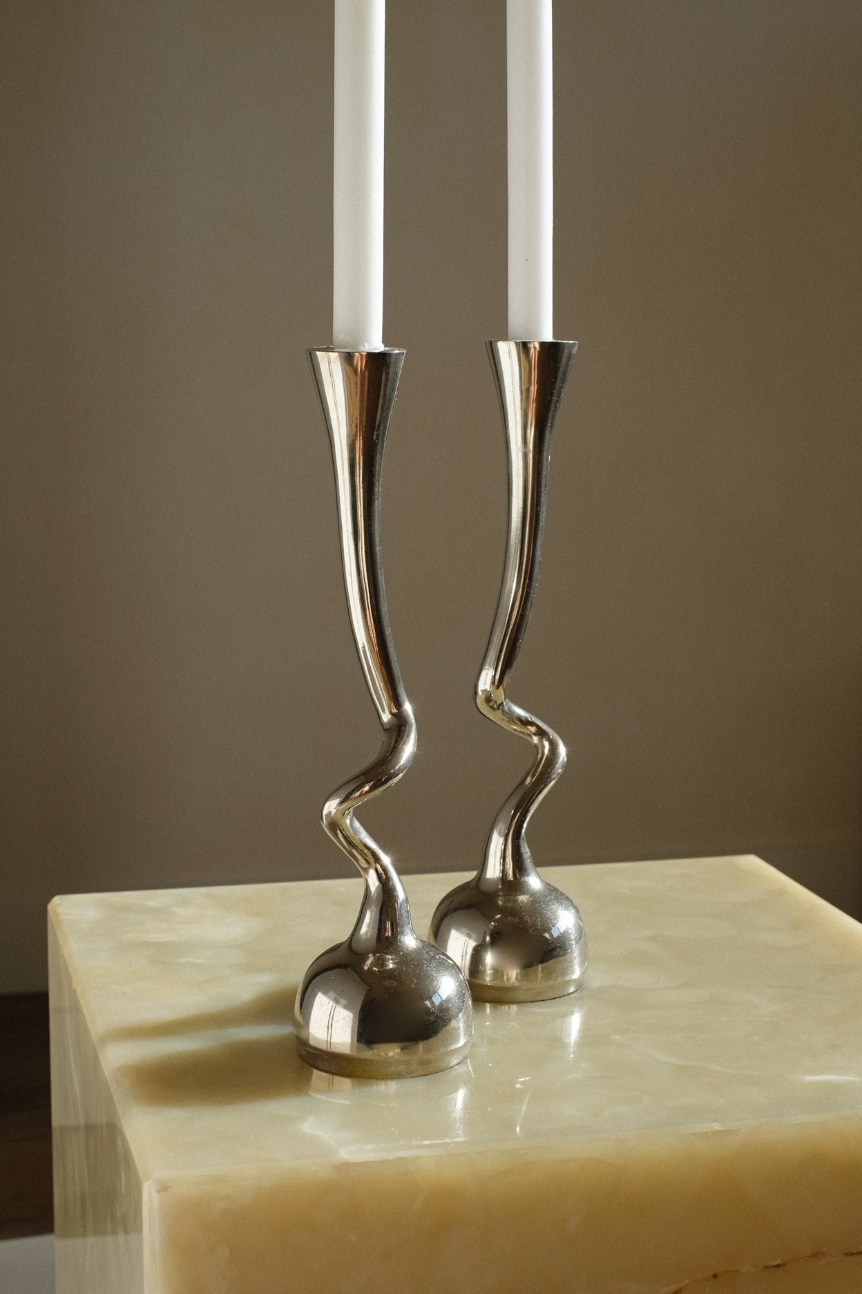 Pair of Curled Candleholders — side angle showing polished metal finish