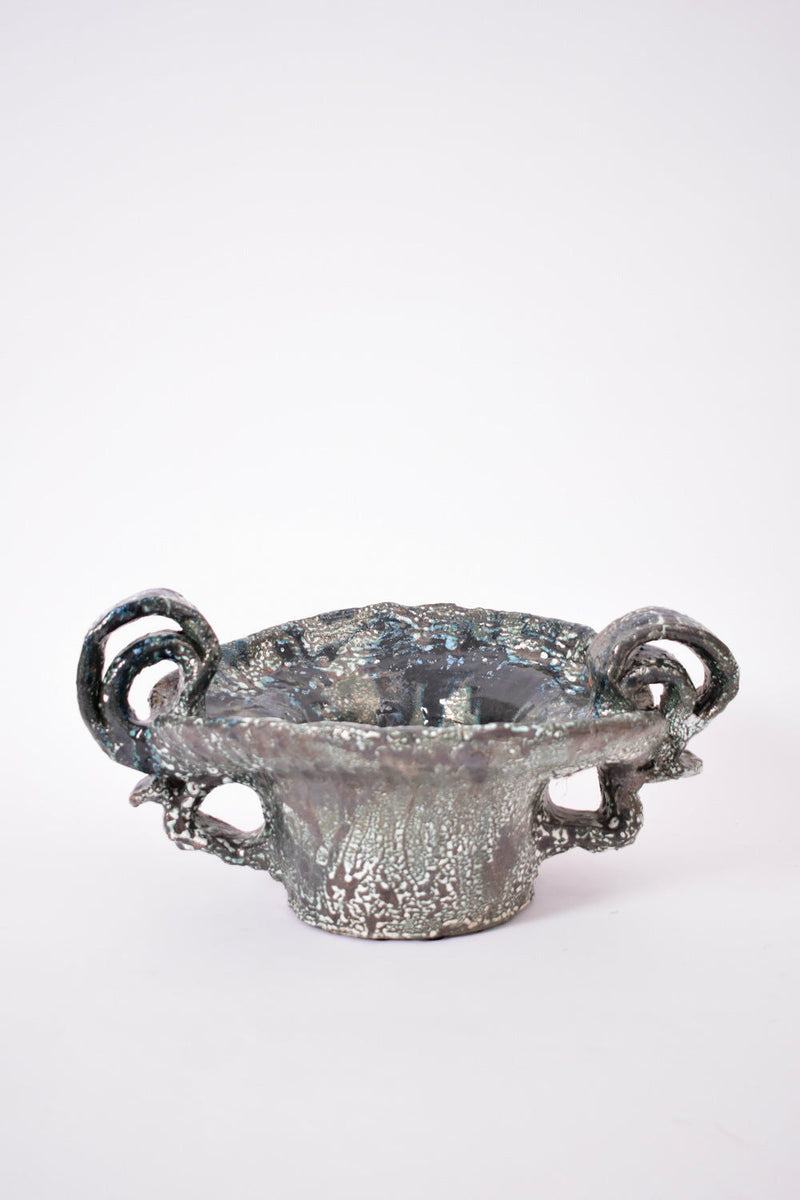 The Barracuda Interiors Helder Handles Large Ceramic Bowl, 2025 features a textured metallic silver finish and organic form, creating a striking modern accent against a plain white background.