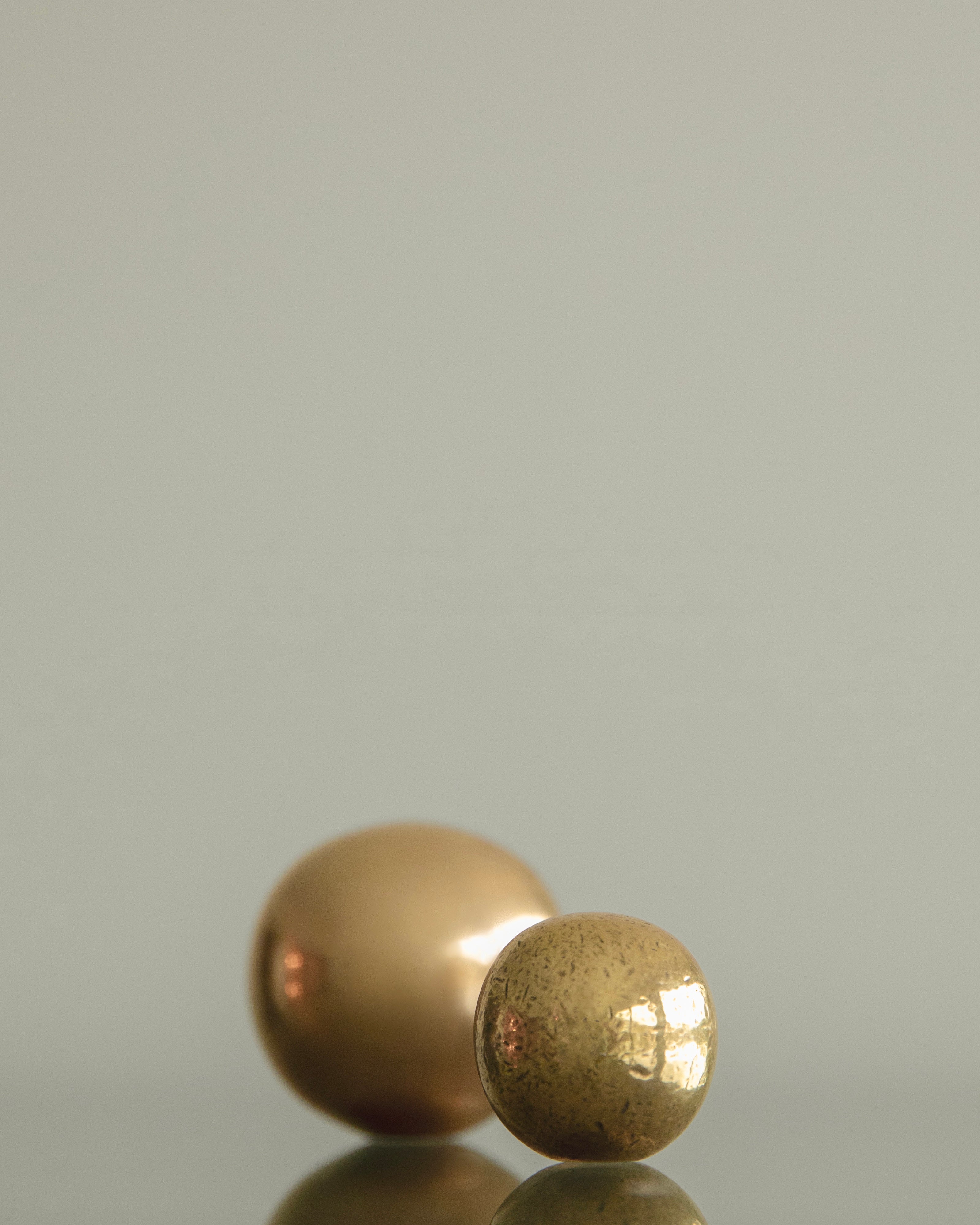 CERCLE Cabinet Knob Medium — close-up of brass knobs on reflective surface