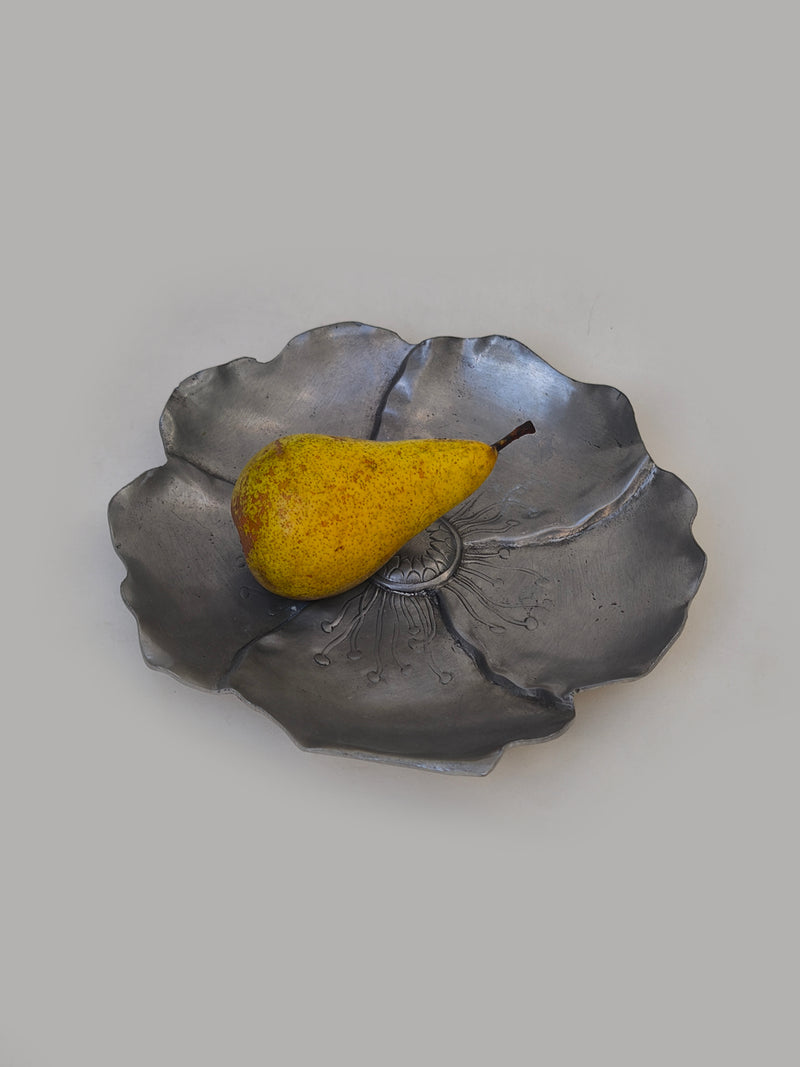 Flower pewter vide poche — close-up with yellow pear on surface