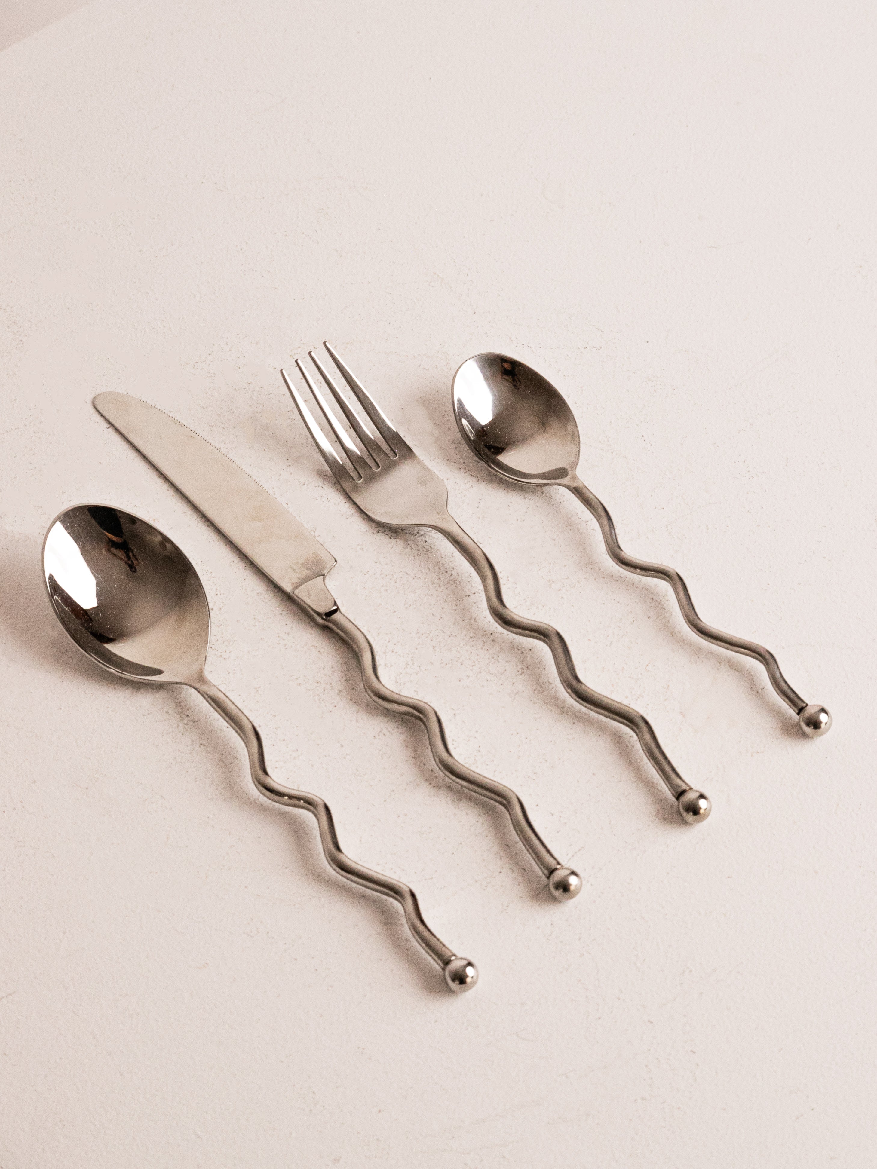 16 piece Wavy 80s Cutlery in Stainless Steel — close-up of wavy handles on utensils