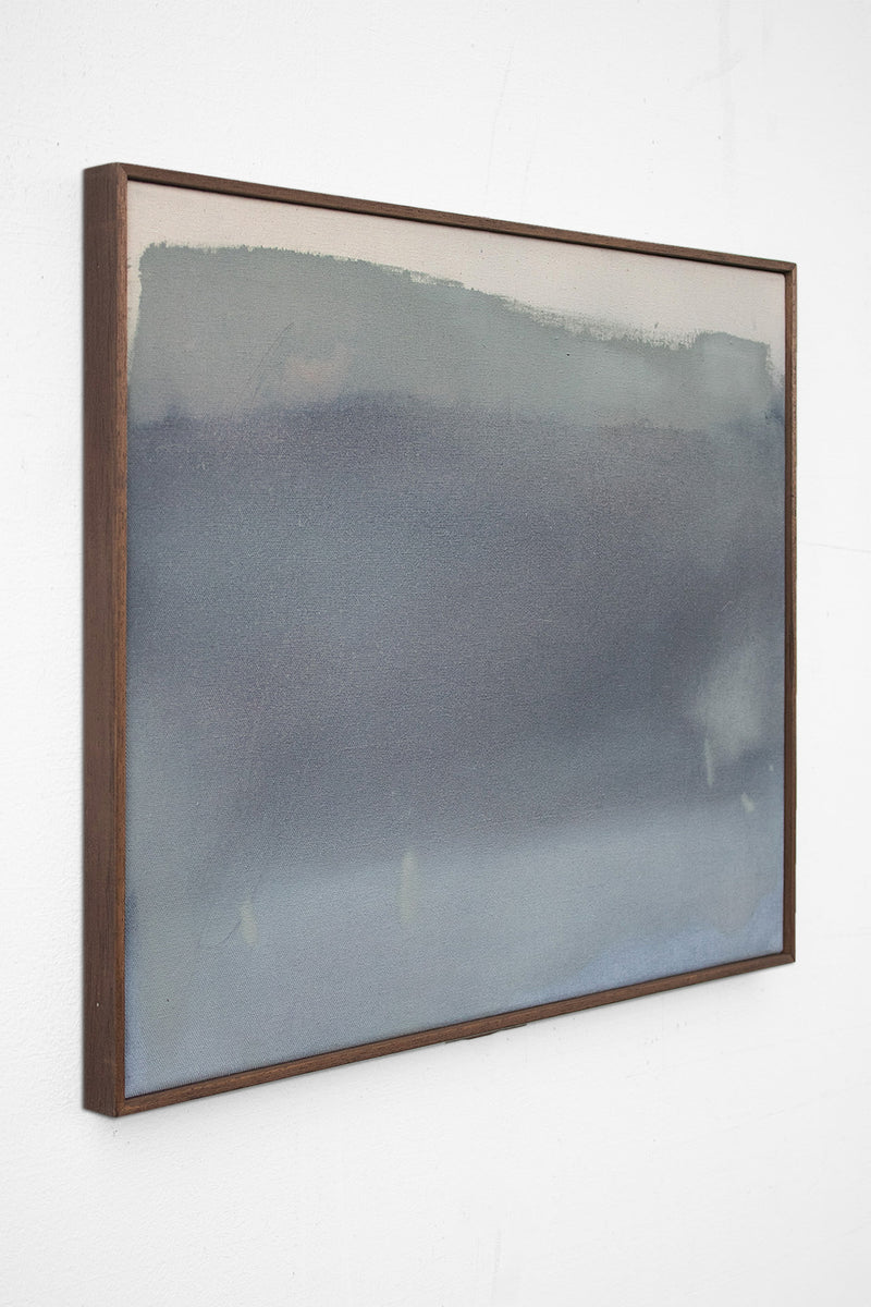 Dawn Grey" by David Hardy is an original acrylic on linen, featuring soft blue and gray tones that evoke a calm, misty landscape. Elegantly framed in dark wood, it stands out beautifully against a white wall.