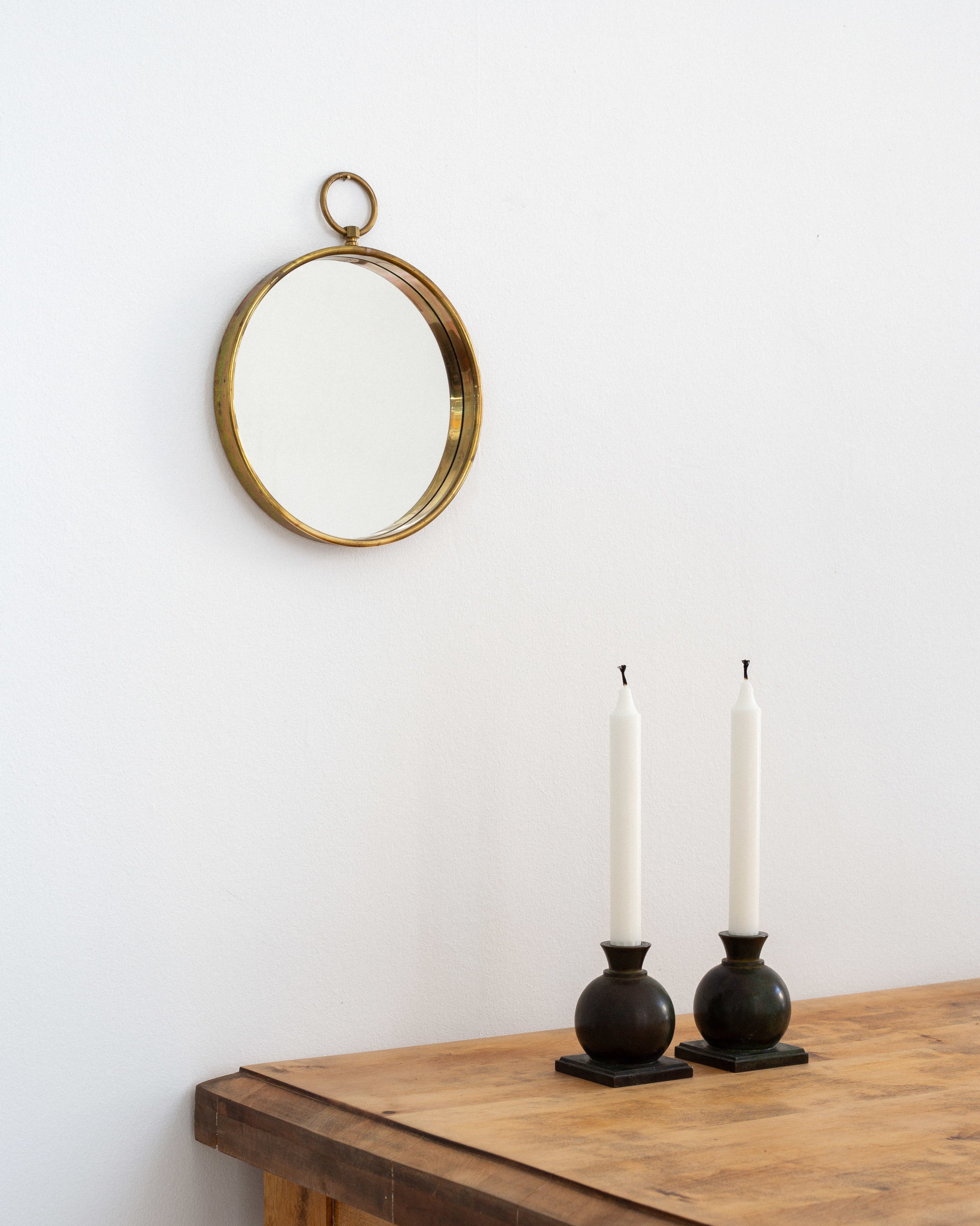 Scandinavian Mid-Century Round Brass Mirror — hung above wooden table with candles