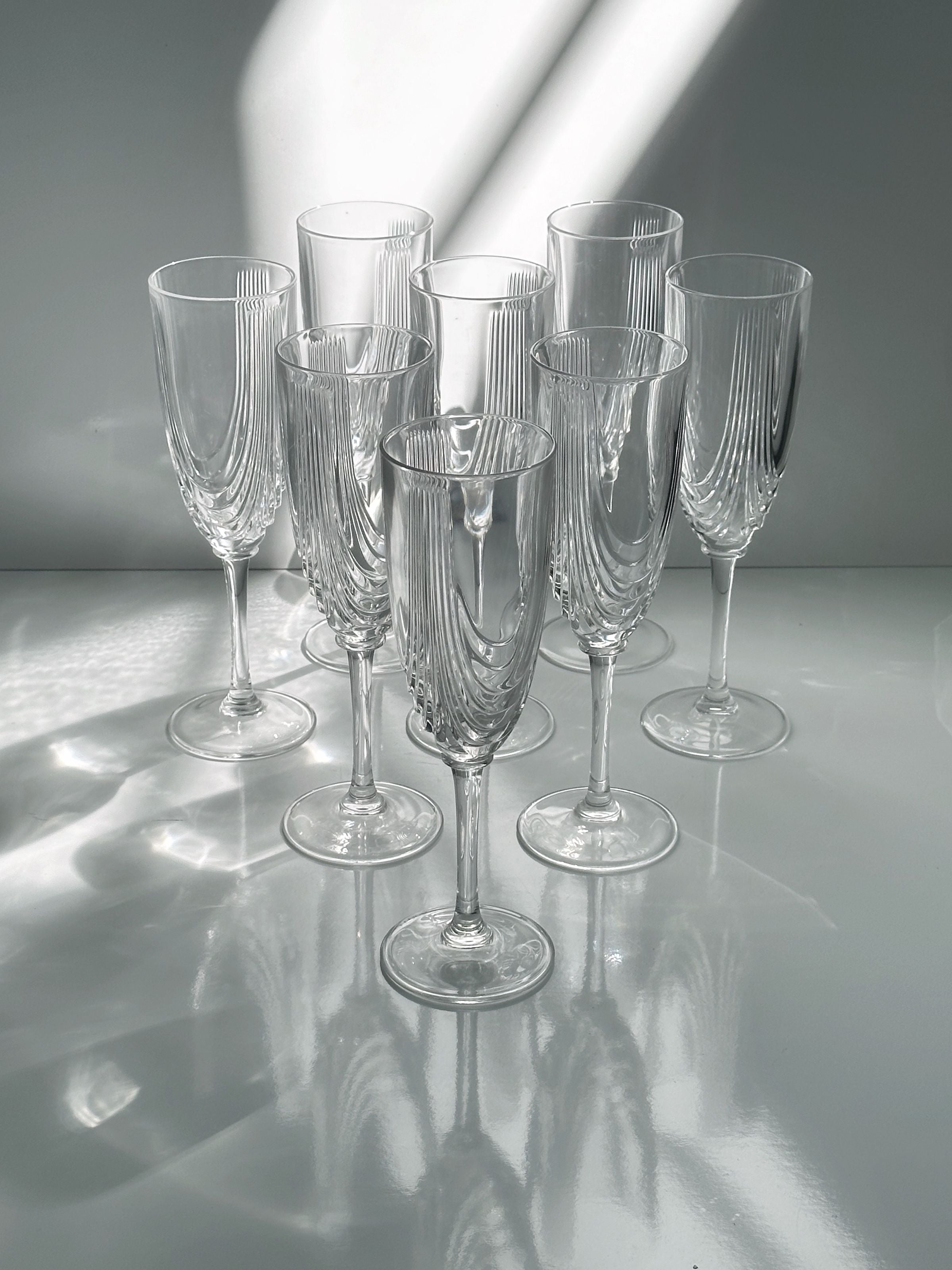 2 Italian Art Deco Crystal Glass Sets of 8 and 6 — top view of clear glass drinkware on white surface
