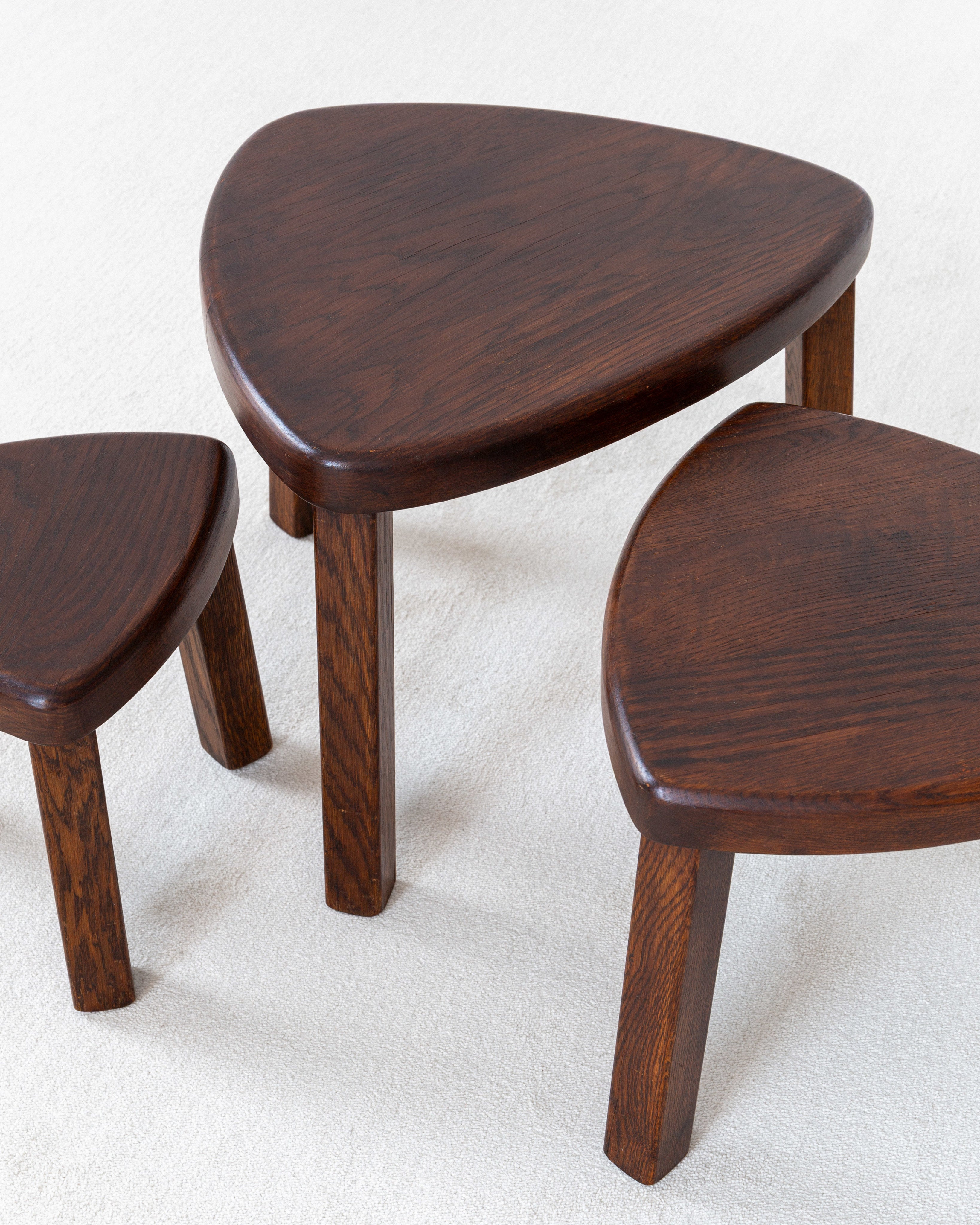 Set of Three Oak Brutalist Nesting Tables, Netherlands, 1970s — close-up of triangular oak surfaces on light fabric