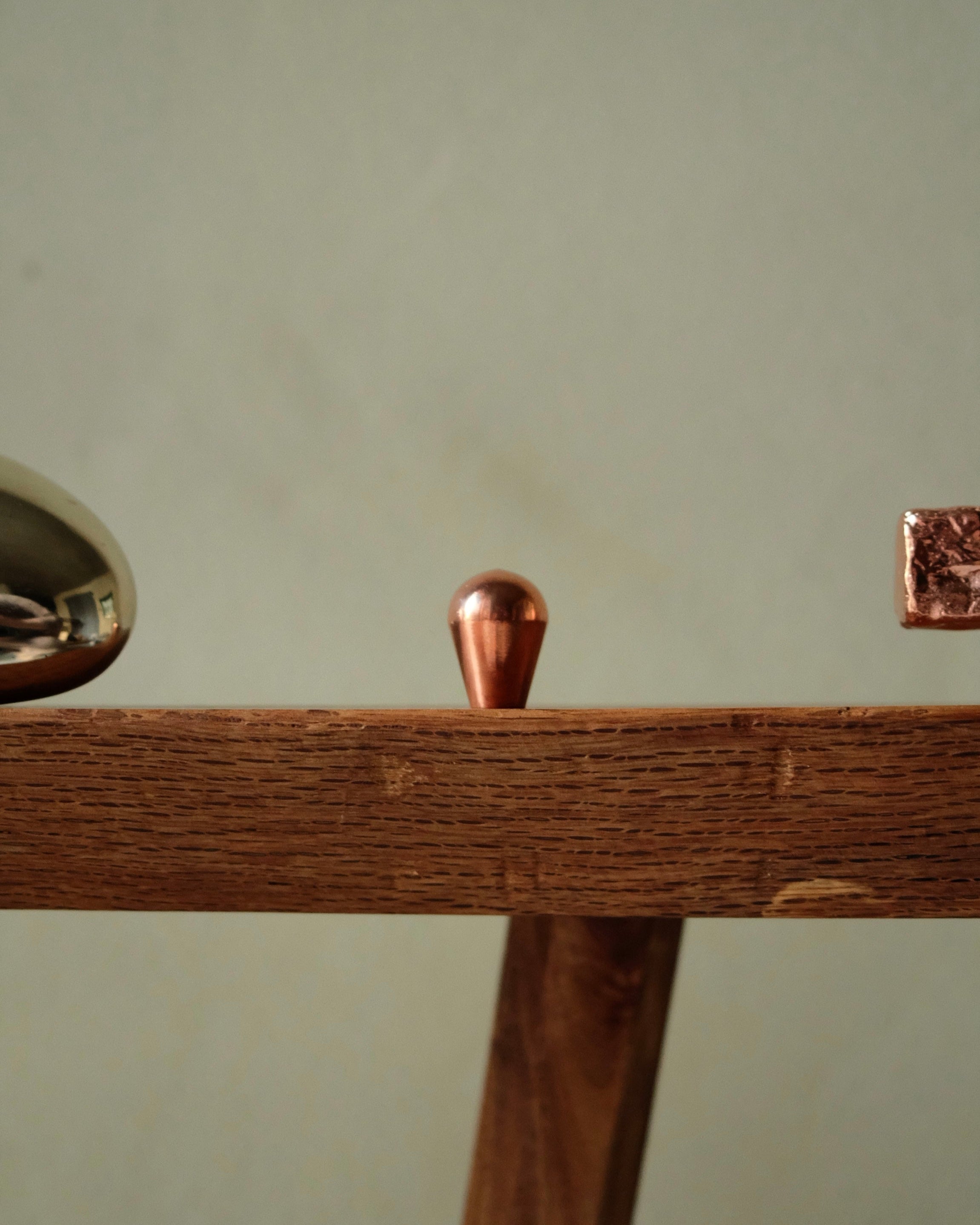 LUA Cabinet Knob — side view of copper knob on wooden surface