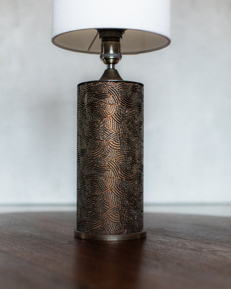Bronze textured cylindrical table lamp with white shade detail