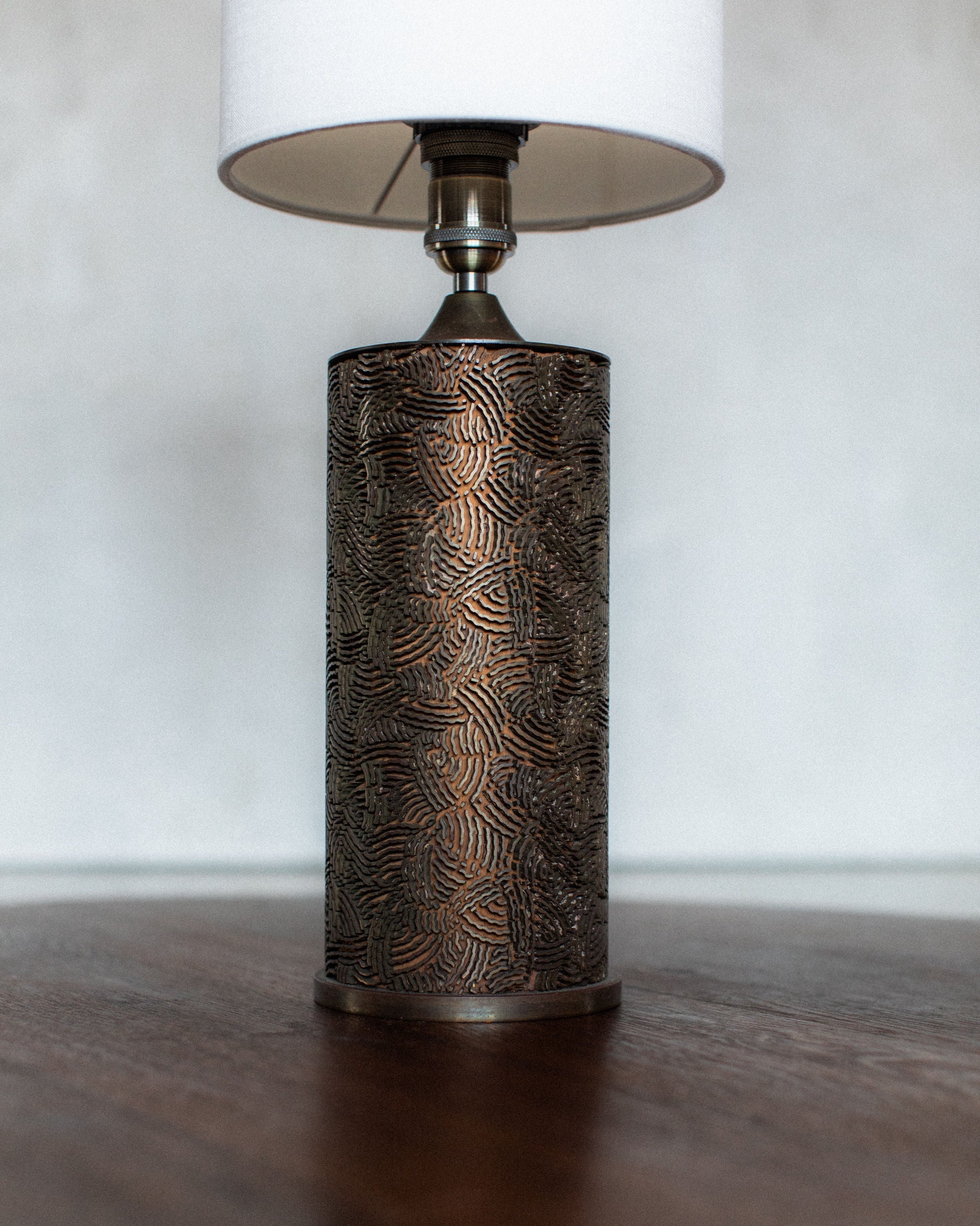 Bronze textured cylindrical table lamp with white shade detail