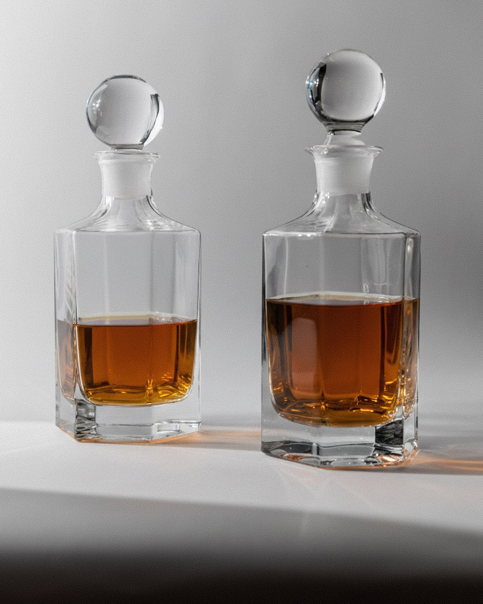 1970s Glass Decanter Set of 2 — close-up of clear glass with amber liquid