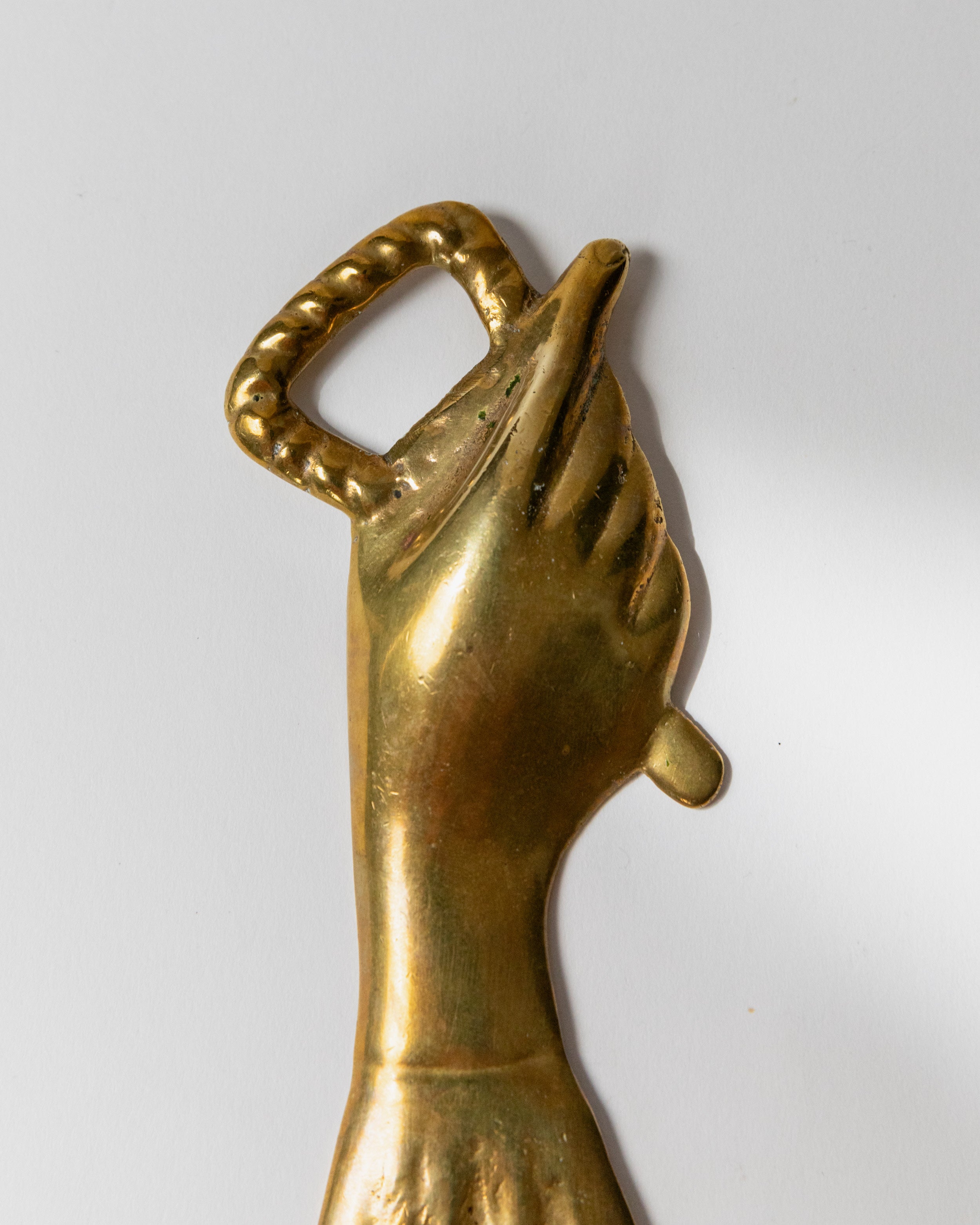 Close-up detail of brass bottle opener hand grip with twisted ring