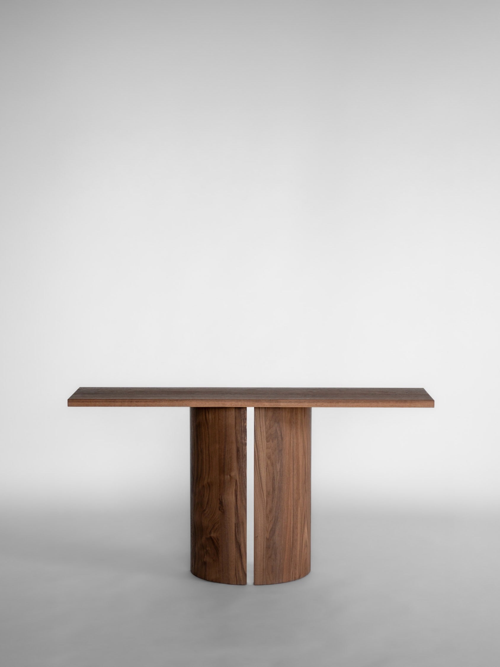 Aperta Console — front view of walnut table in minimalist setting