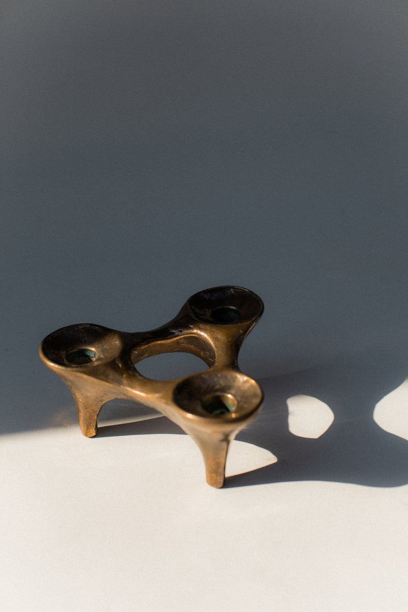 Bronze sculptural candleholder with organic curved form and three holders