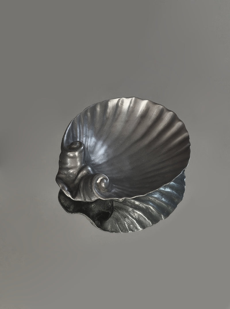 Shell-shaped pewter vide-poche with ribbed texture and curved edges