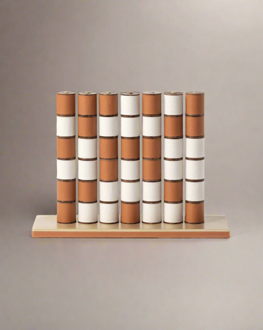 A set of cylindrical containers with alternating brown and white bands, arranged neatly on a wooden shelf against a white background, reminding one of a Pinetti Jumbo Connect Four game.