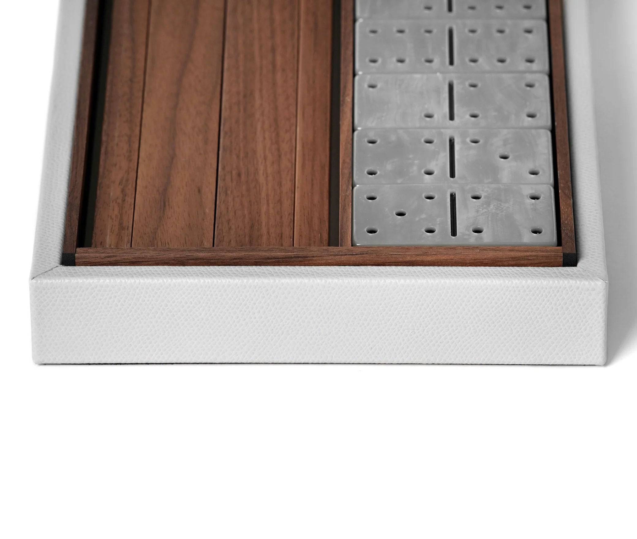 Close-up of a Pinetti Dominoes Set with wooden and steel sections framed in white, showing a contrast of materials and high-quality craftsmanship.