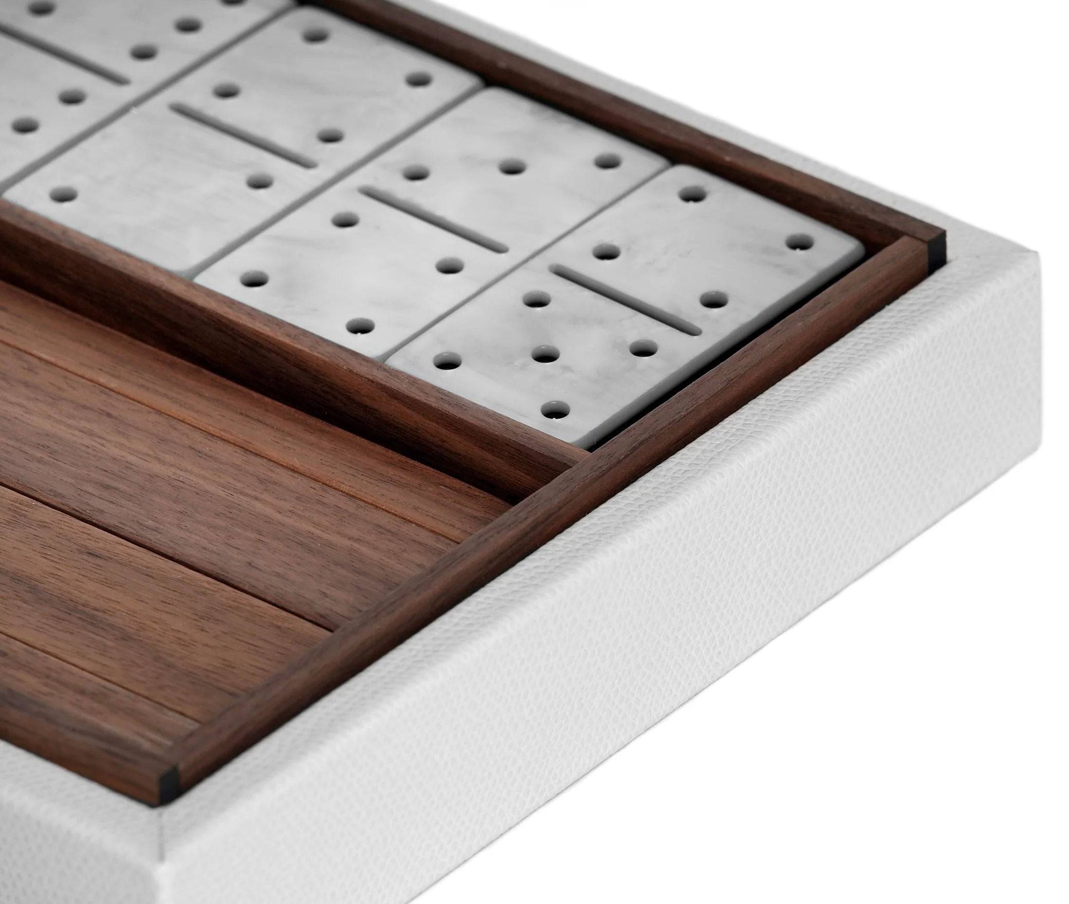 Close-up of a Pinetti luxury domino set in a wooden box, showcasing pieces neatly arranged, with focus on their dot patterns and high-quality craftsmanship against a white background.