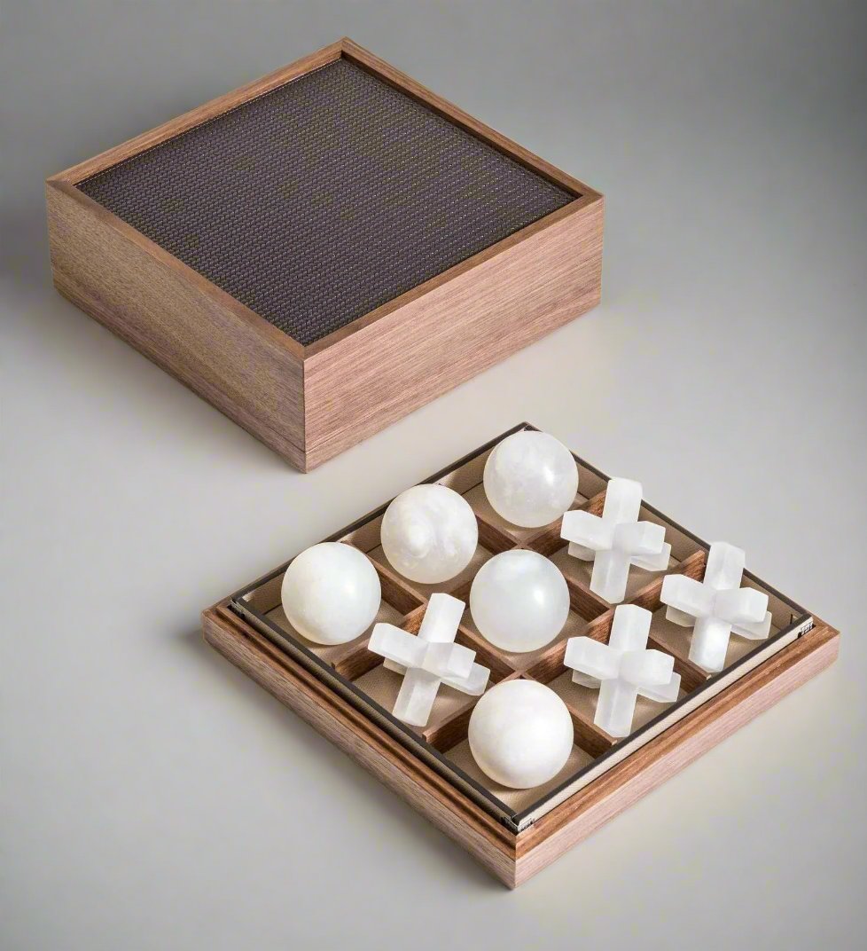 An elegantly crafted luxurious Pinetti Volterra alabaster Tic Tac Toe game set with a board and pieces displayed on a light background, including five x's and four o's modeled as spheres.