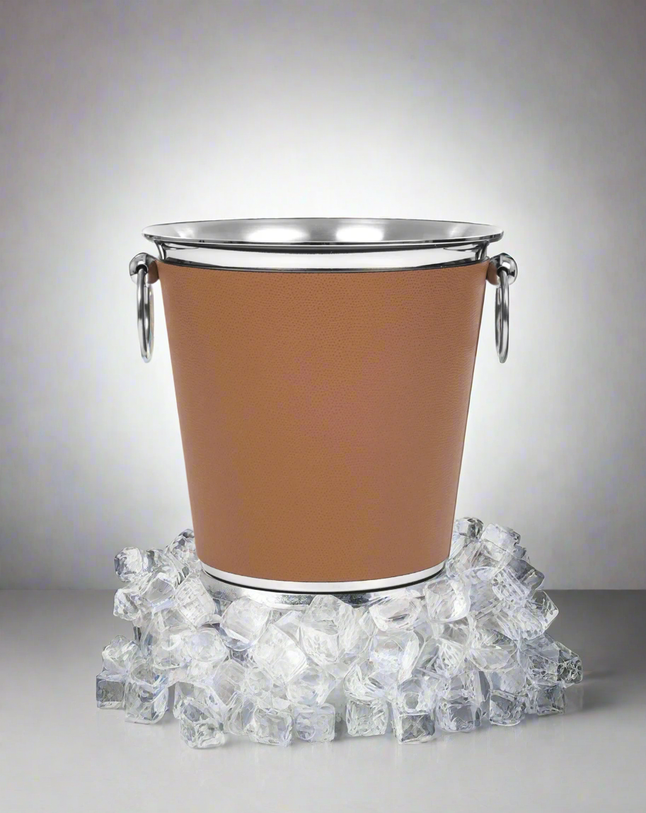 A modern Pinetti champagne bucket with a brown leather exterior and stainless steel rim and handles, isolated on a white background.