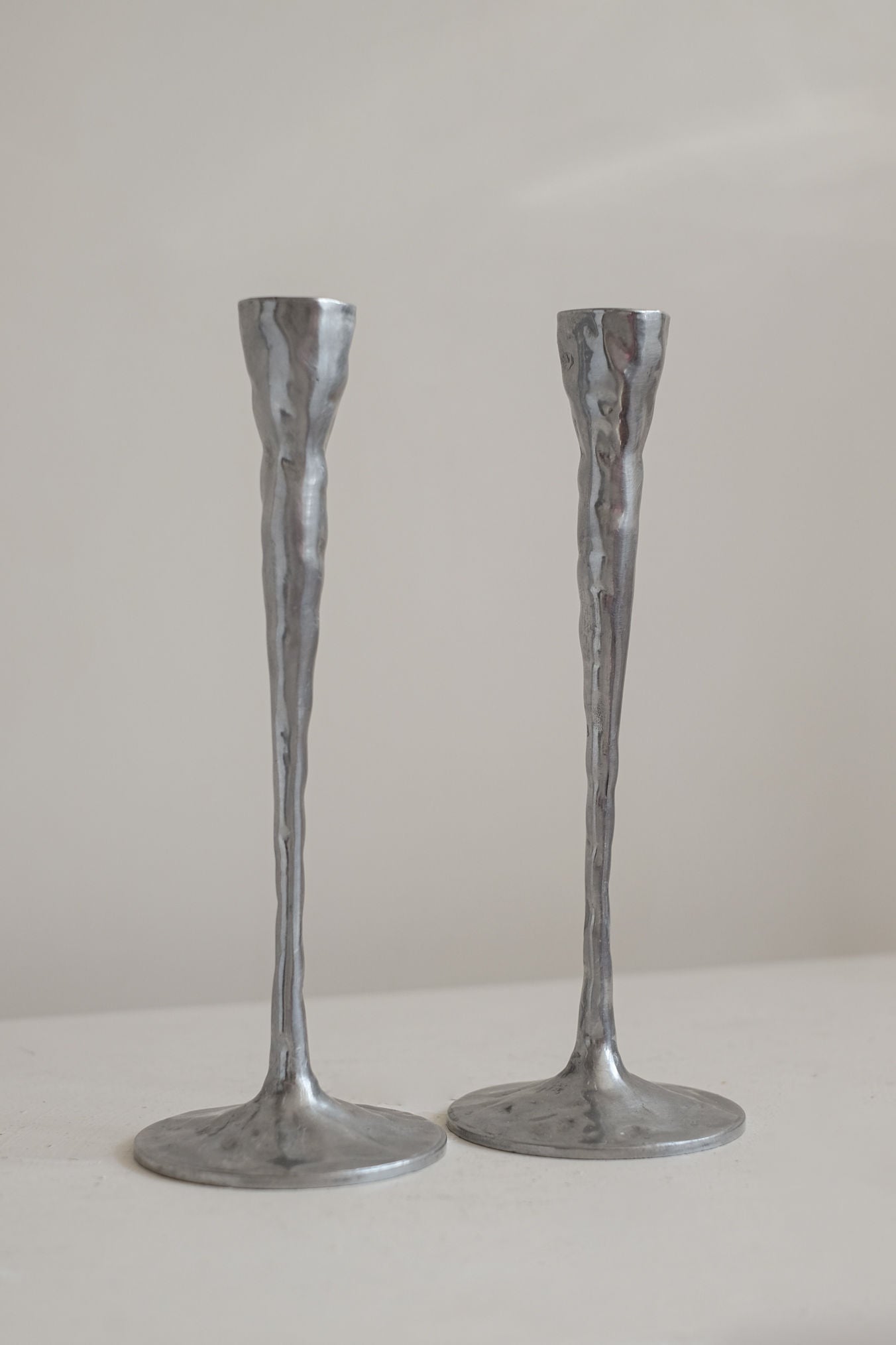 Pair of Aluminium Candle Holders — top view on light surface
