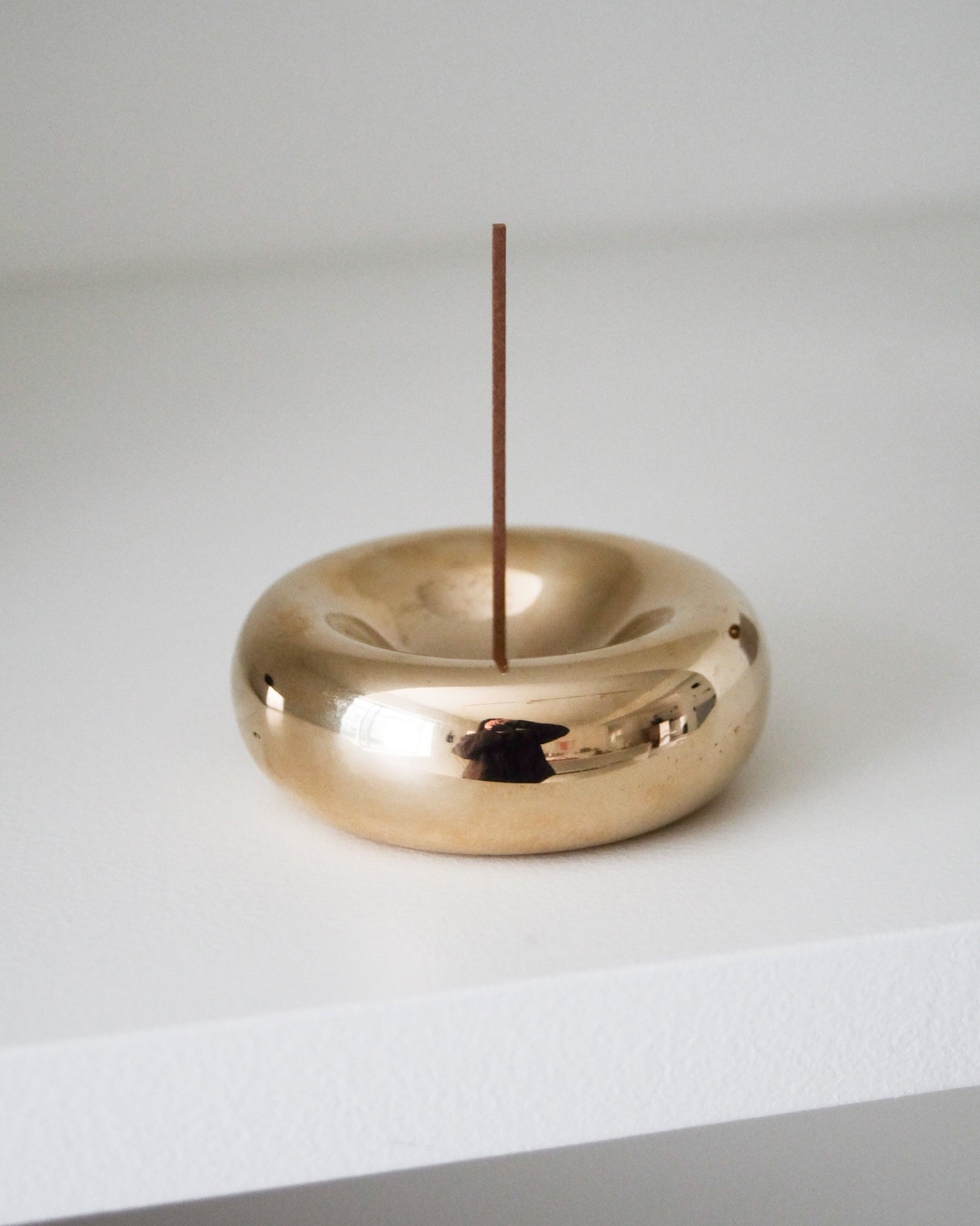 BASIN Incense Holder — polished brass on white shelf