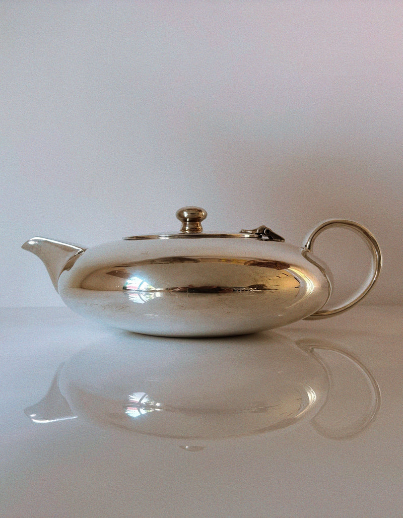 Elegant silver plated teapot with curved spout and reflective finish