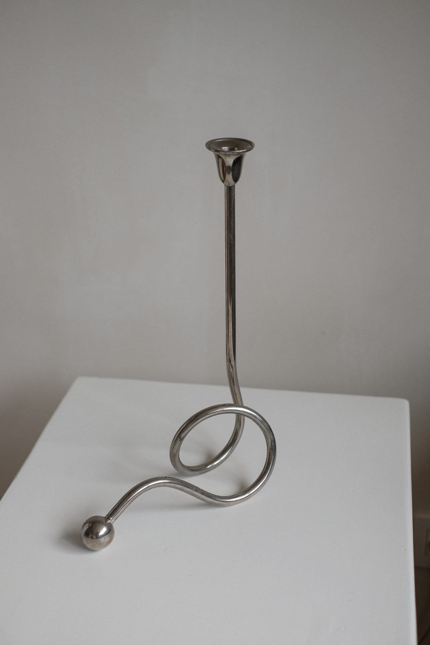 Chrome Candle Holder by Guido Niest — angled view on white table