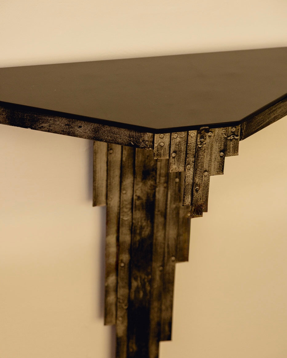 Sculptural Console Table — top view of black metal surface and textured legs
