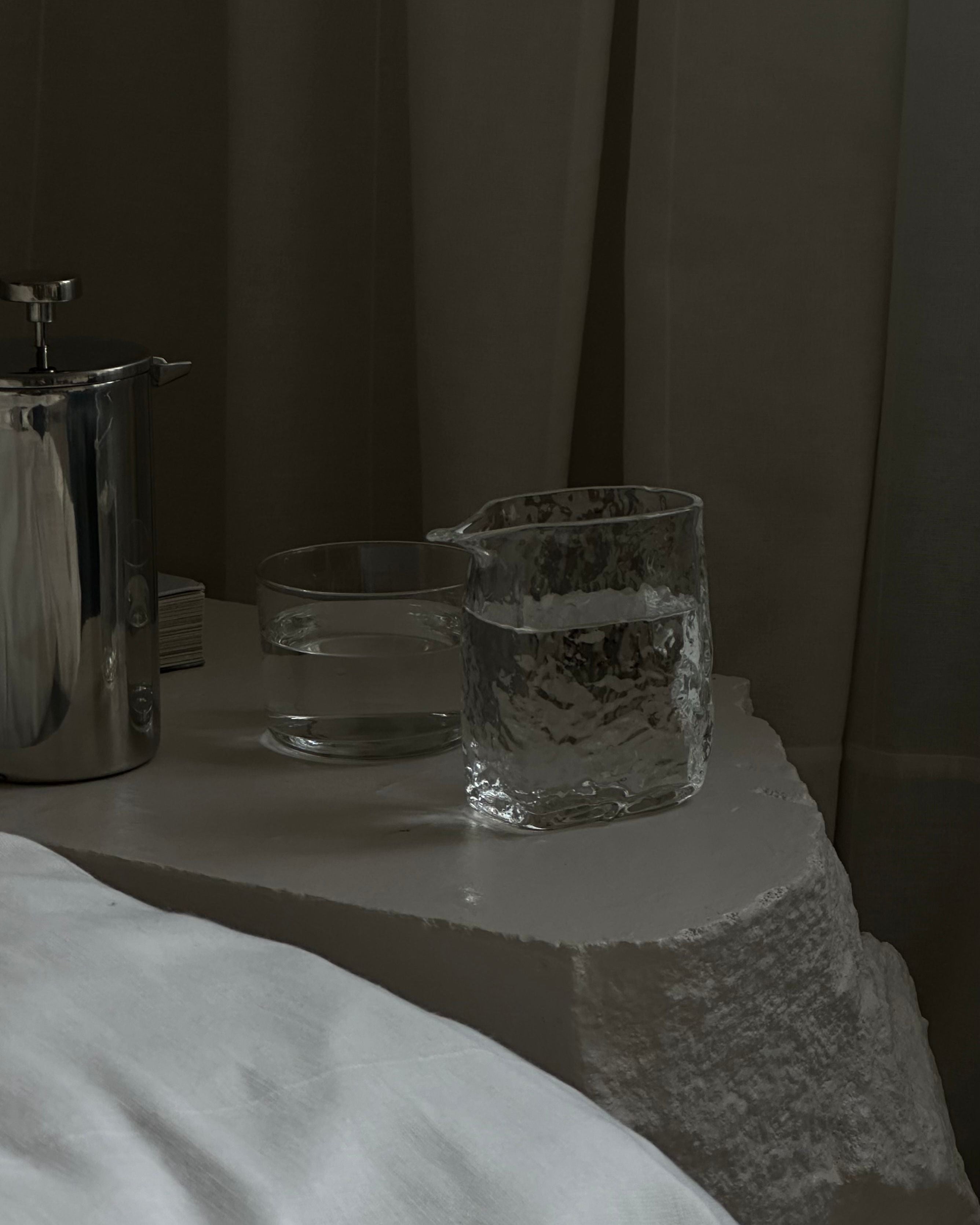 DELIRIUM' small glass pitcher — top view on textured stone surface