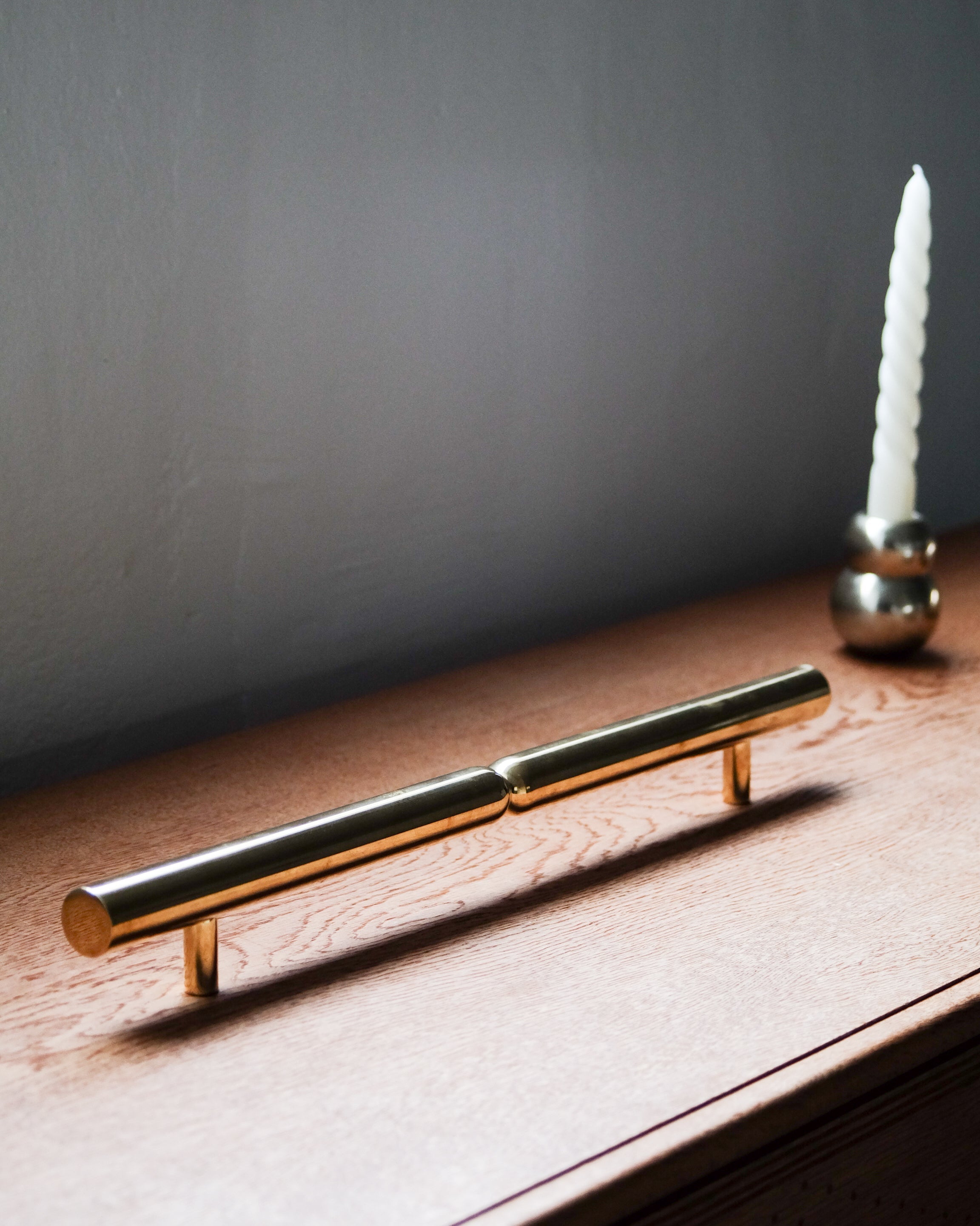 TOTEM Appliance Pull — top view of polished brass handle on wood surface