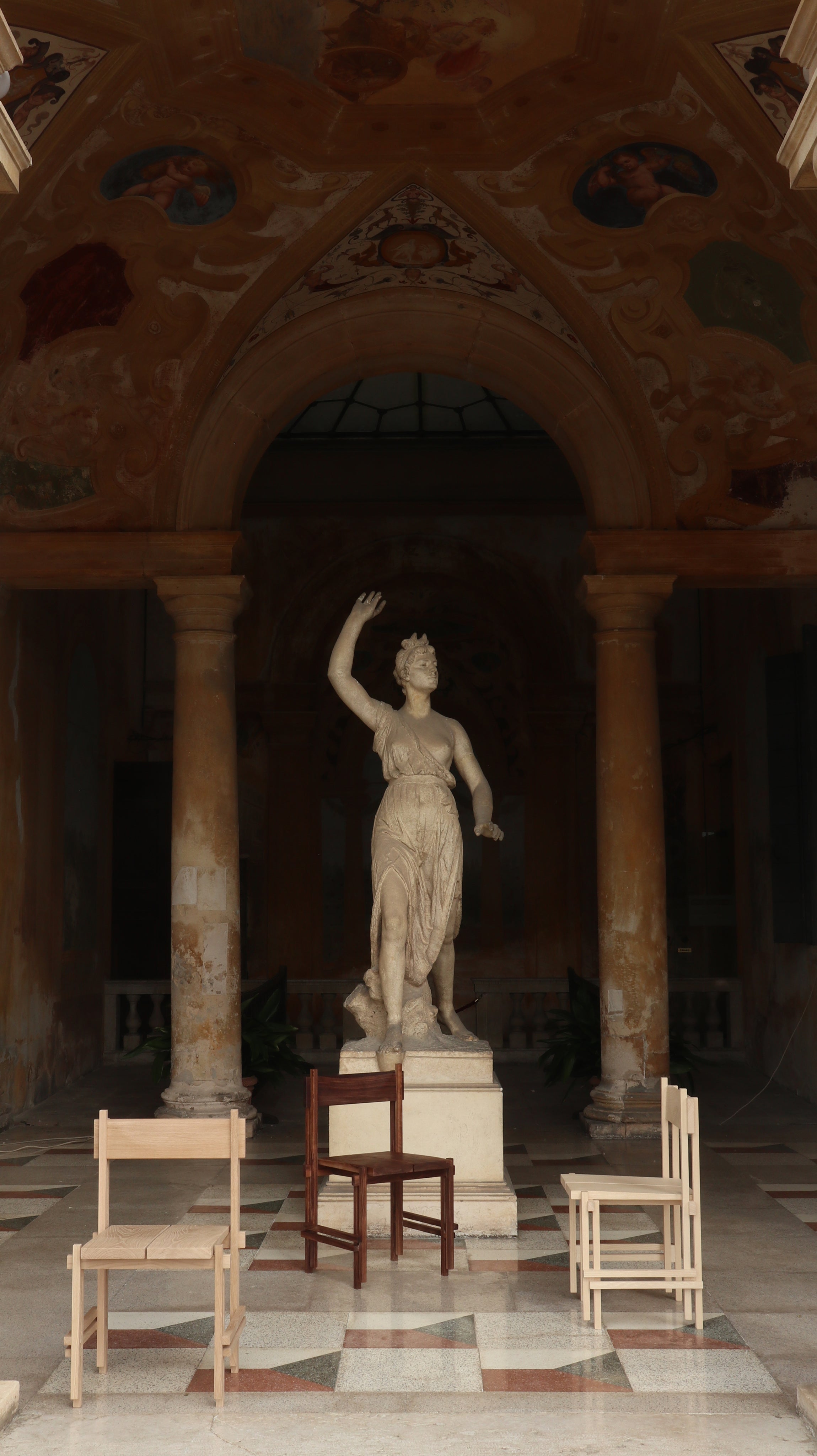 Stack chair arrangement in ornate classical interior with marble statue