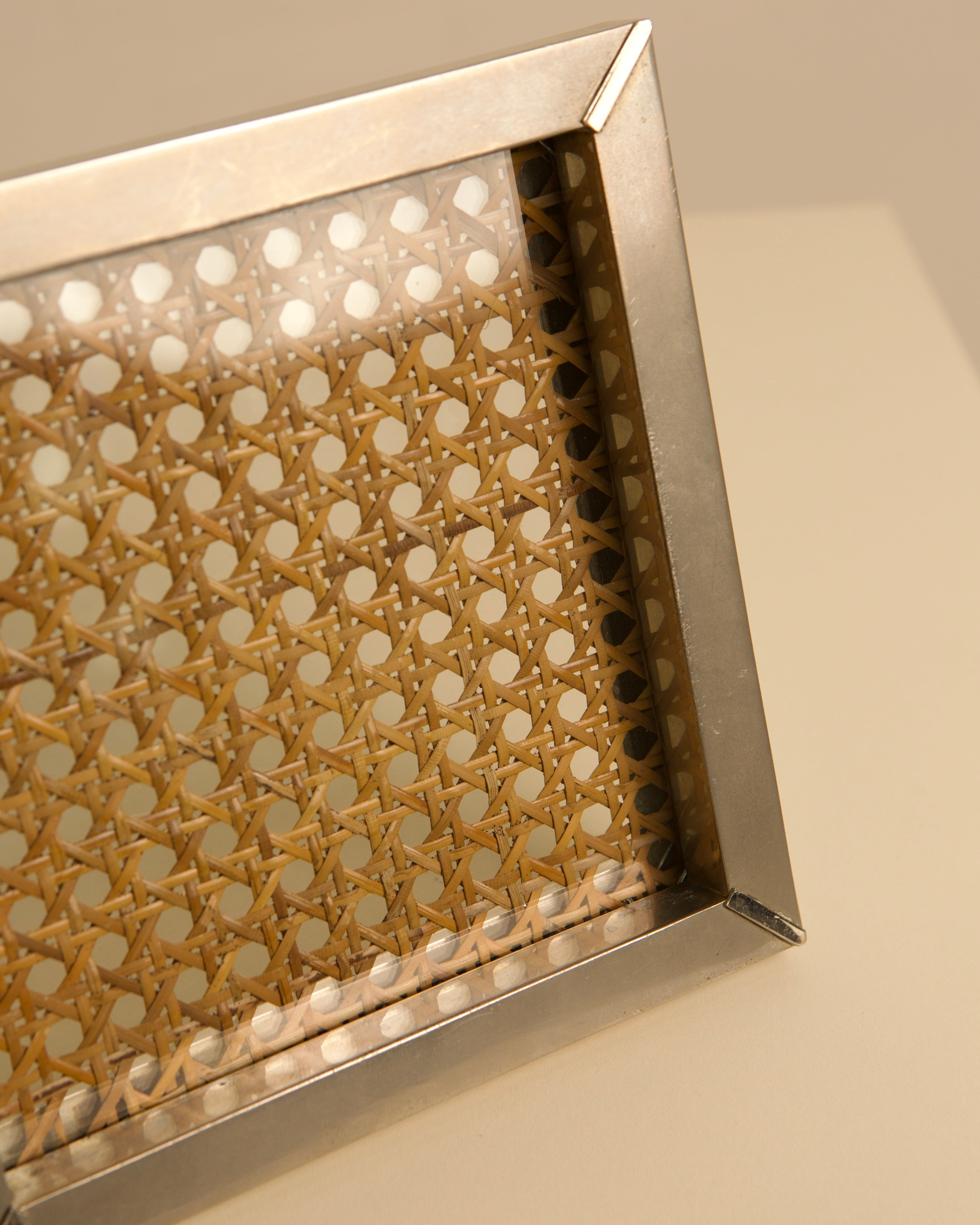 Close-up detail of Italian metal vide-poche with cane webbing