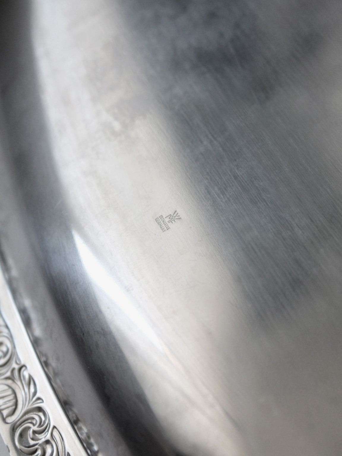 WMF "Baroque" Stainless Steel Tray And Coasters Set — close-up of polished stainless steel surface