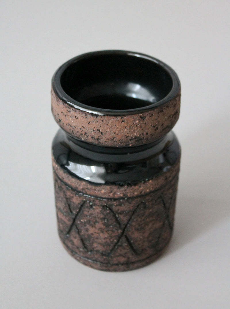 Black ceramic vase with textured brown speckled exterior detail