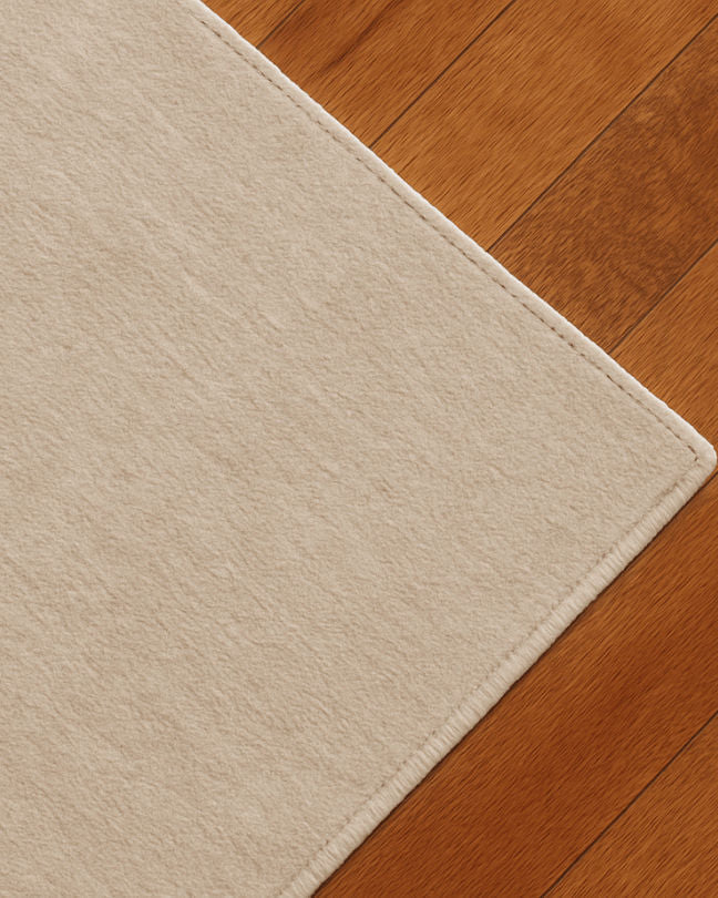 Rug 100% Wool New Zealand - Blanc Cassé — side angle on wooden floor