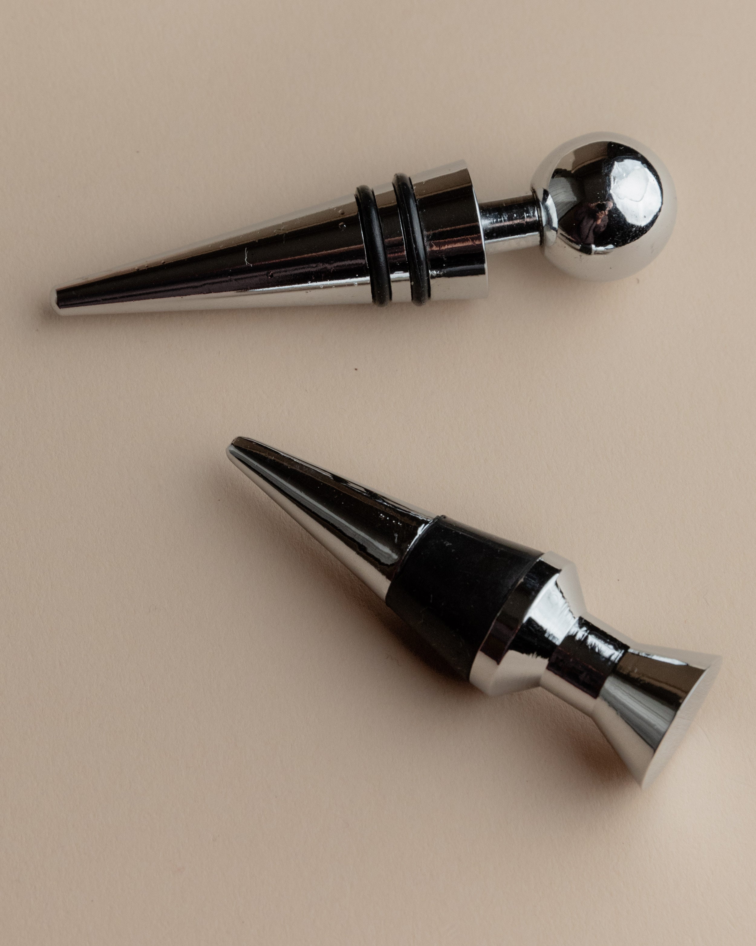 Vintage 1980s Bottle Stoppers Set of 2, Metal Geometric Conical Design Italy — overhead view on neutral background