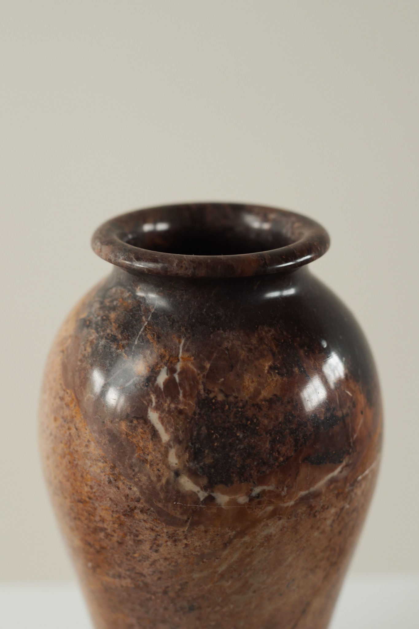 Vintage marble vase detail showing rich brown veining patterns