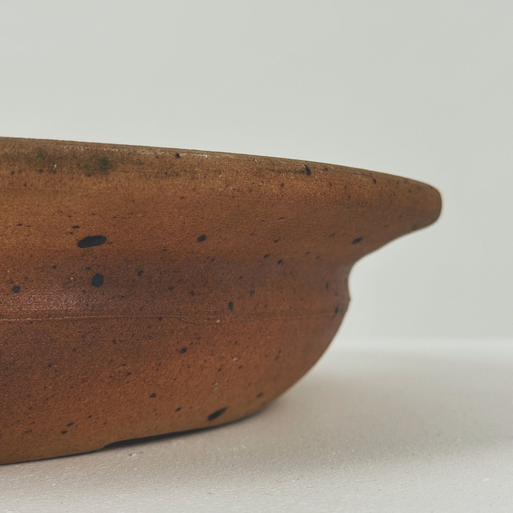 Close-up detail of speckled brown stoneware bowl rim by Digan