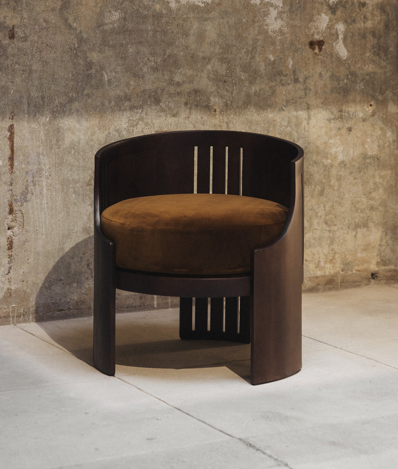 Le Fauteuil 01 — close-up of dark wood frame with brown cushion