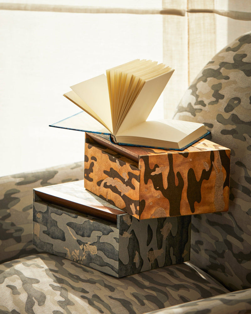 Fortuny Box - Camo Isole Tiger — stacked boxes with open book on armchair