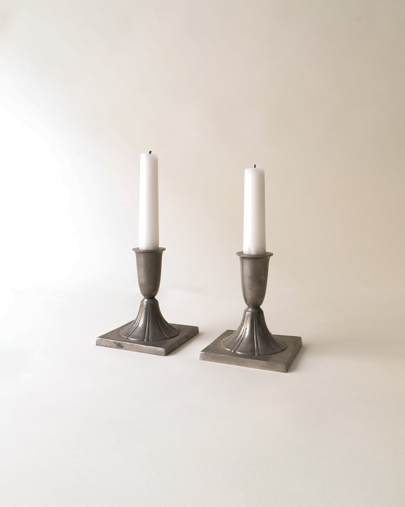 Pewter candlestick pair by Just Andersen with white taper candles