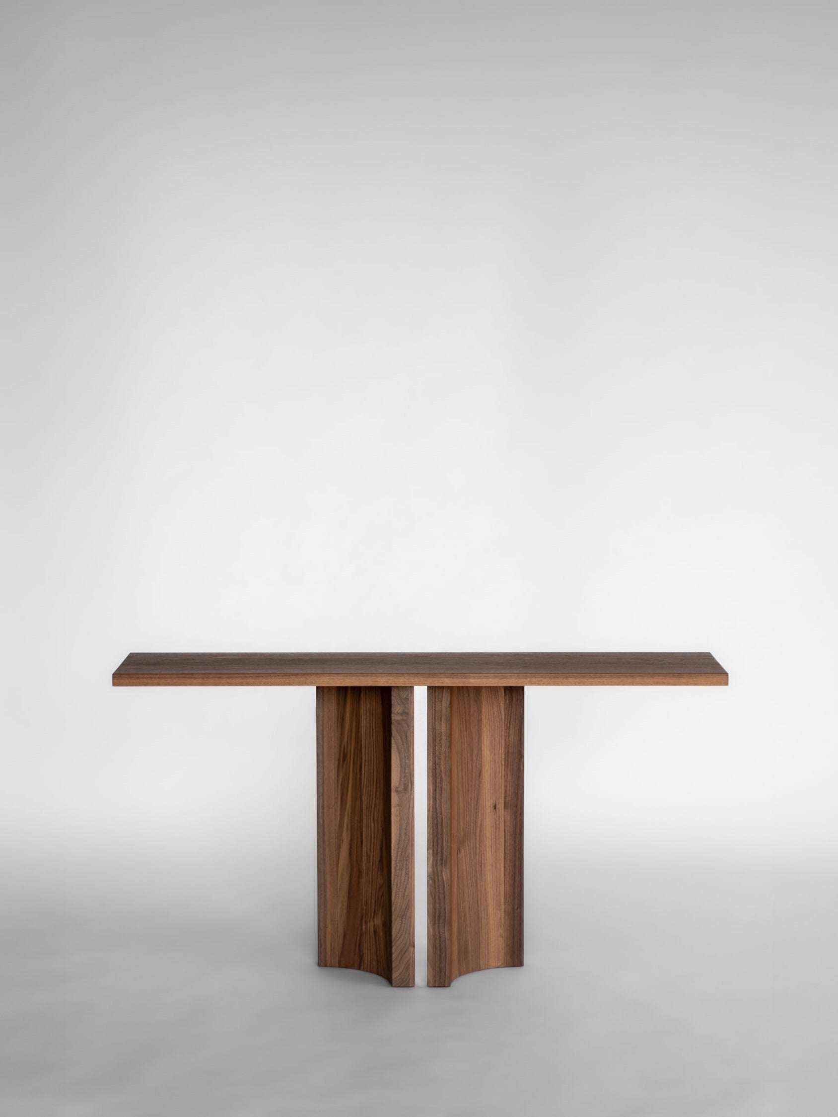 Aperta Console — side angle of walnut table with two legs