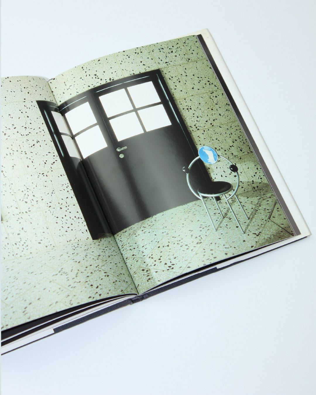 Memphis — open book on textured surface with chair illustration