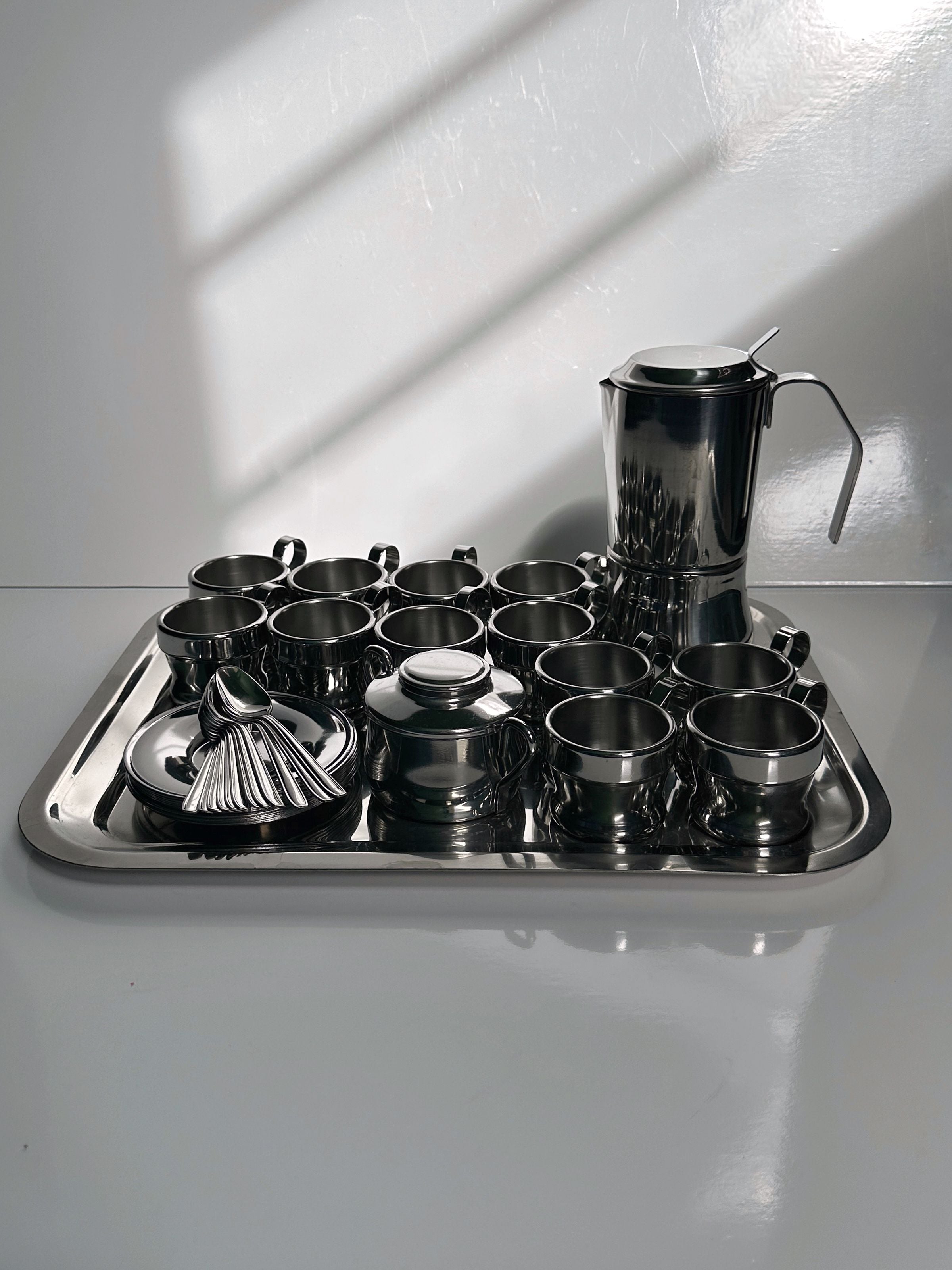 Italian Stainless Steel Coffee Set for 12 Persons — arranged on reflective tray with shadows