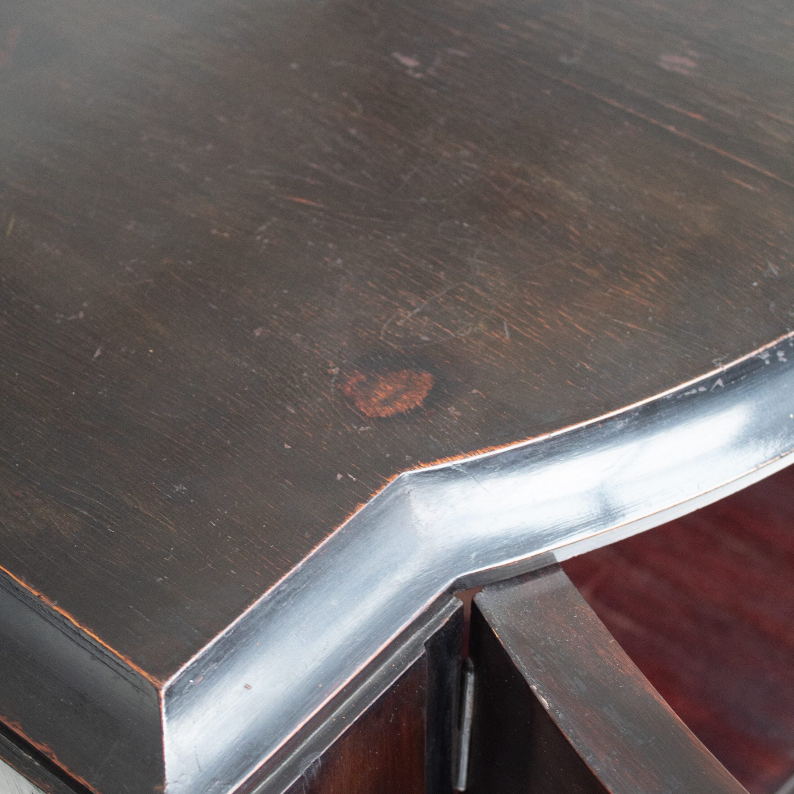 Art Deco Cabinets — close-up of dark wood surface with curved edge