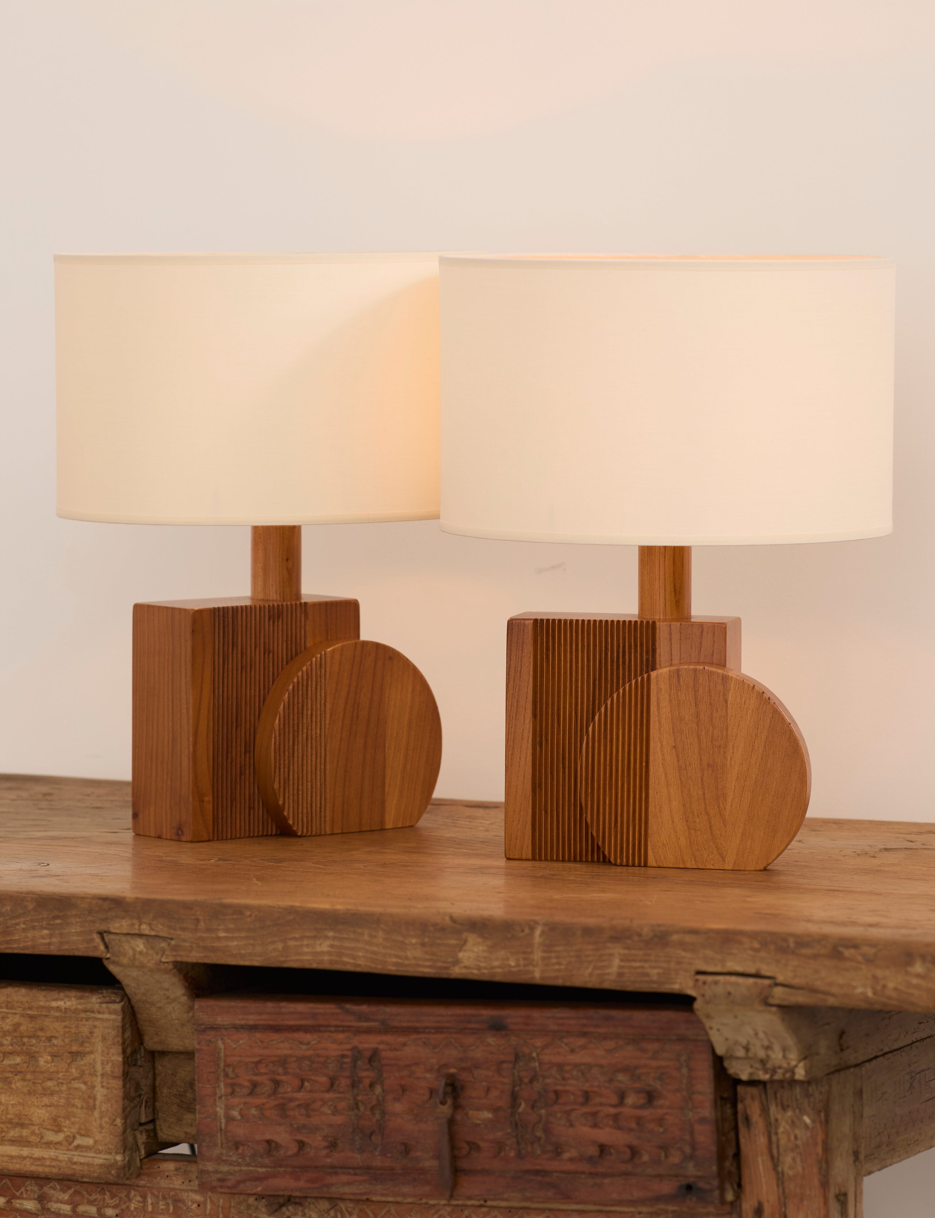 Set of 2 Vintage Artisanal Table Lamps In Solid Wood From France c. 1970 — styled on rustic wooden table with warm light