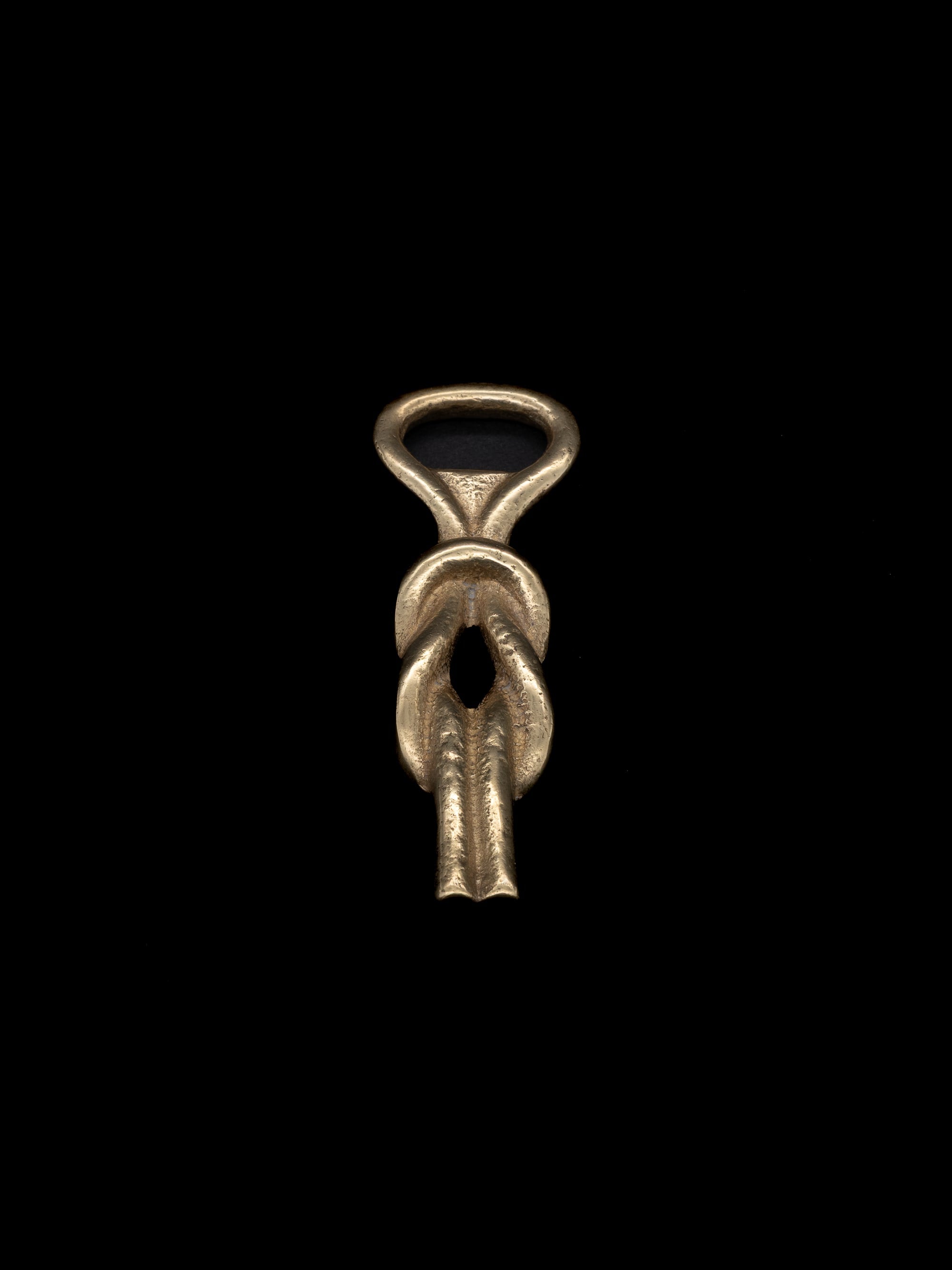 Sailor’s Knot Bottle Opener, Italy, c. 1960s — front view of brass opener on black background